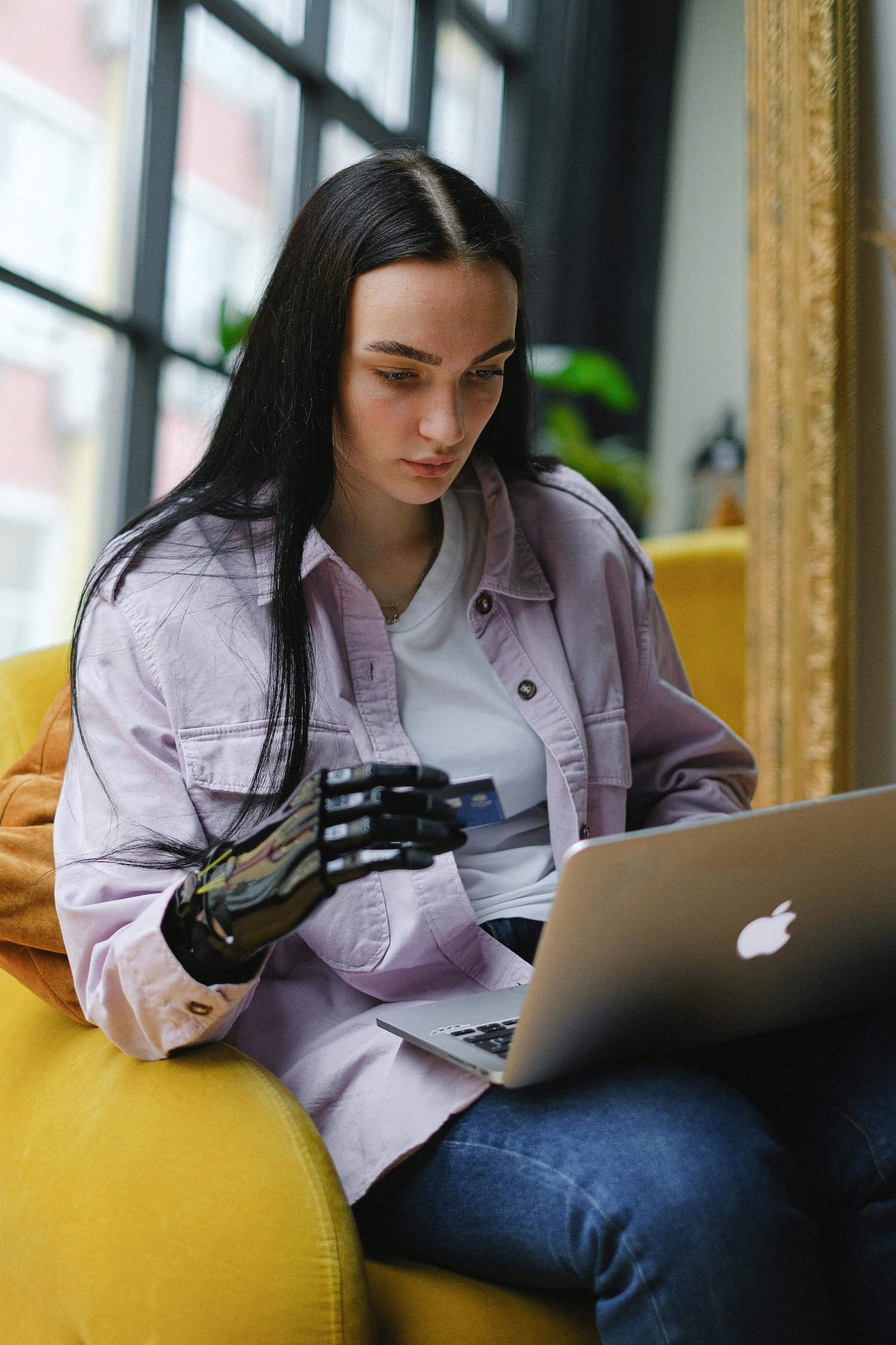 a young entrepreneur with black hair entering details onto her laptop