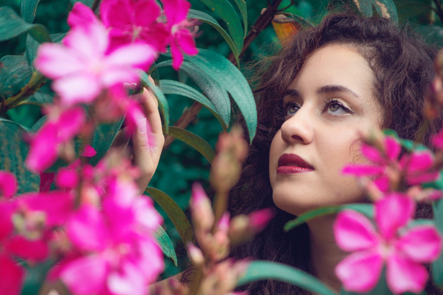 Woman with dreamy eyes among flowers