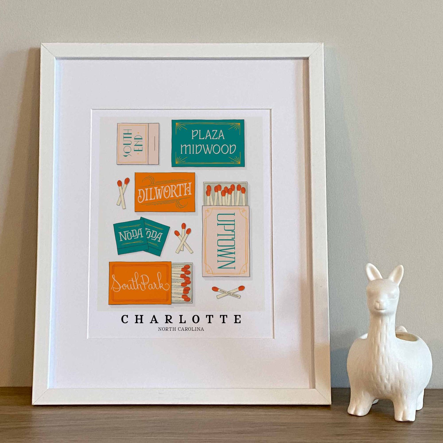 Hand-drawn Charlotte matchbox wall art featuring custom lettering in bright blue and orange tones