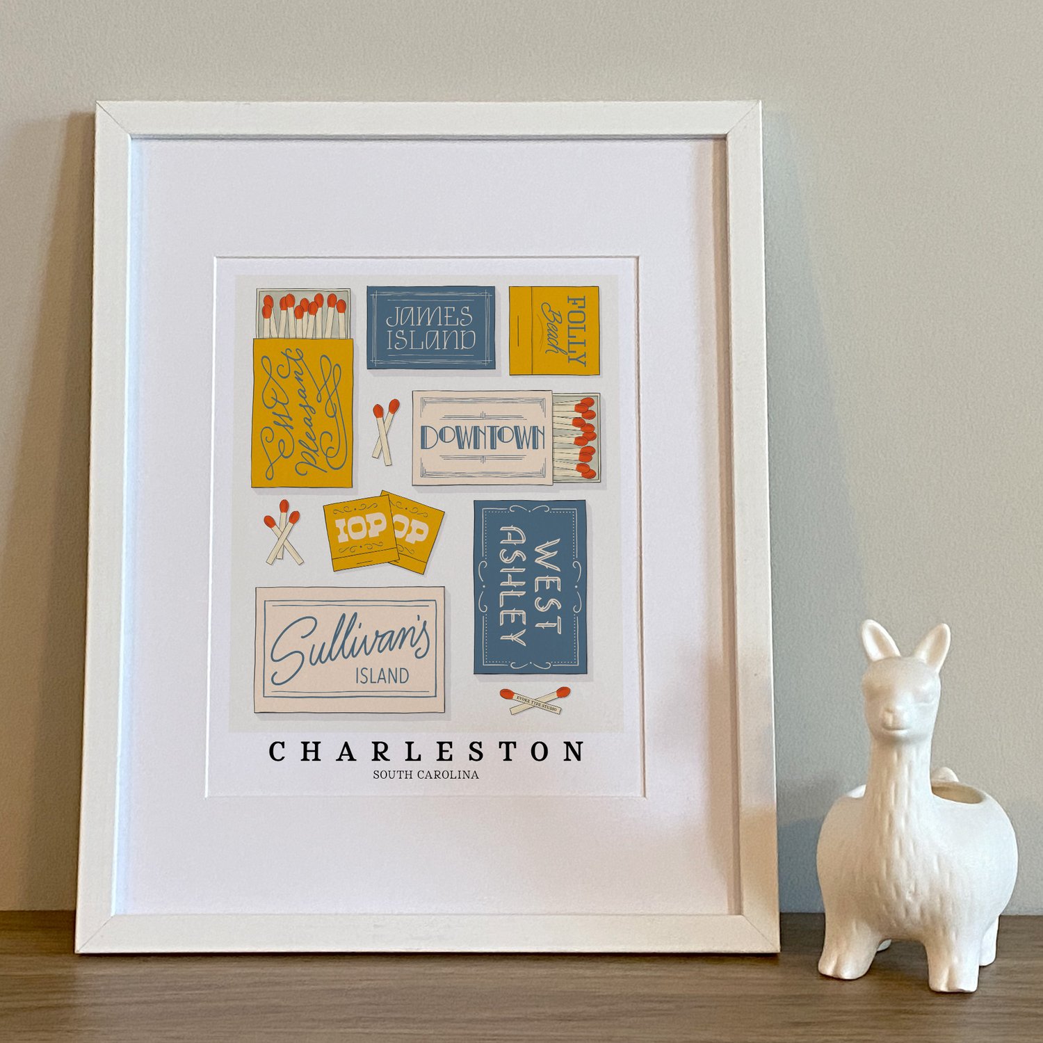 Charleston neighborhood matchbox art print with hand-lettered typography in a color palette of warm blues, yellows, and beige tones