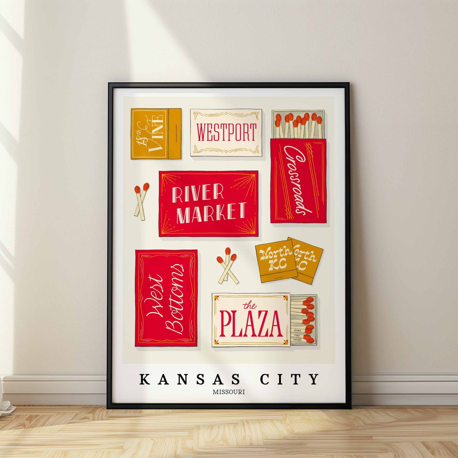 A framed picture of Kansas City, Missouri neighborhoods drawn in various lettering styles on matchboxes. Artwork has a red and gold color scheme