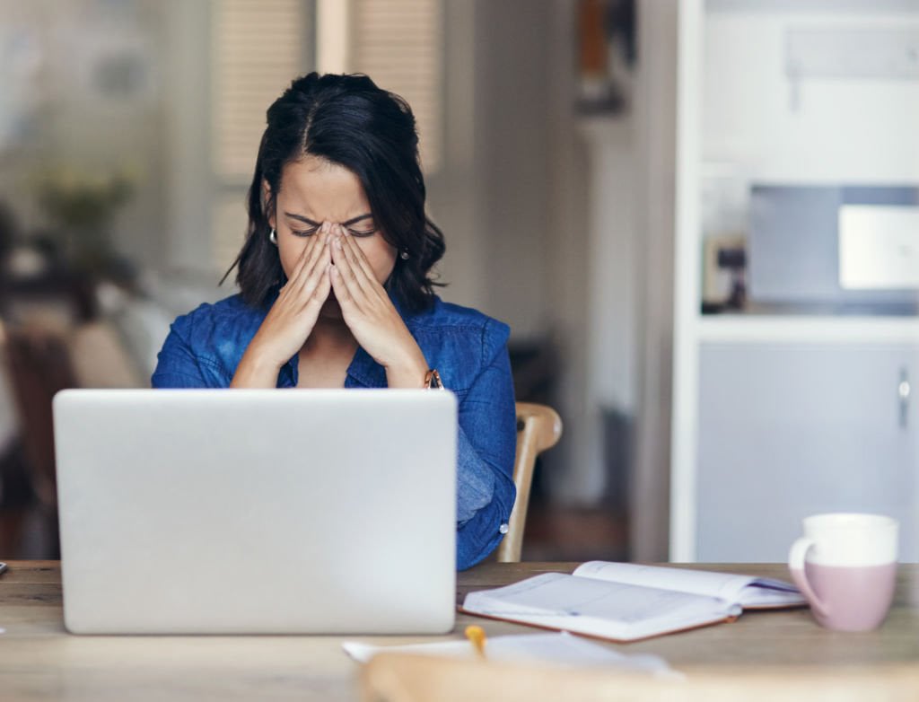 Woman working on laptop feeling stressed out