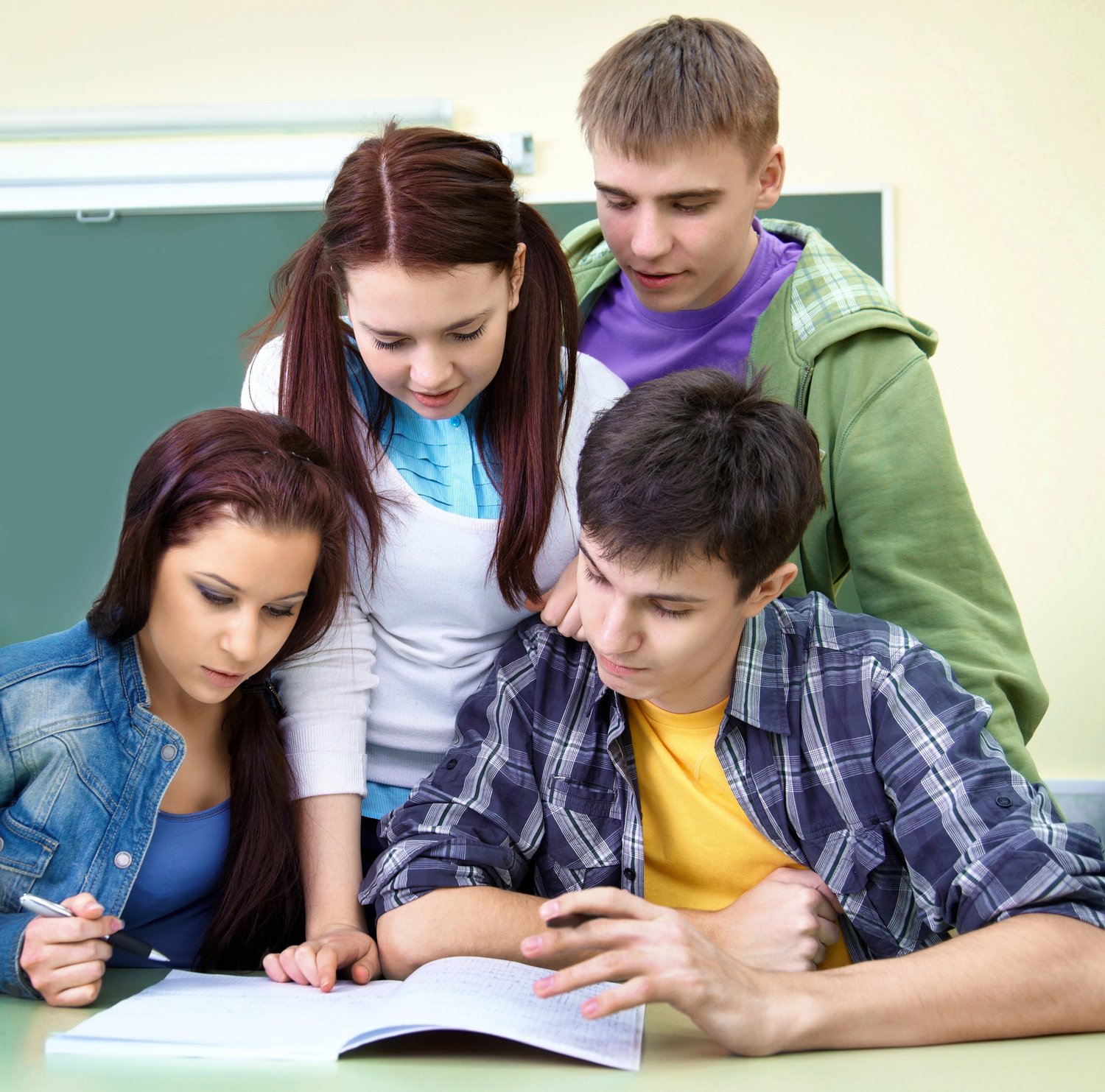 Students studying at a desk with books and notes, preparing for exams