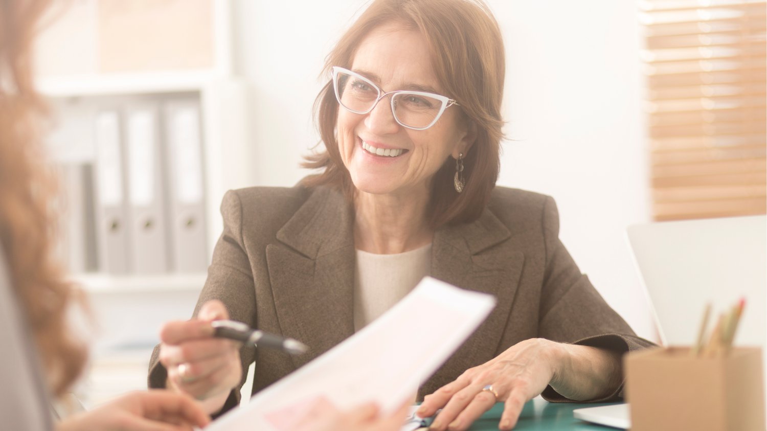 Smiling health coach connecting with a client during a consultation—illustrating authenticity in health coaching and the importance of trust and personal connection over perfection.