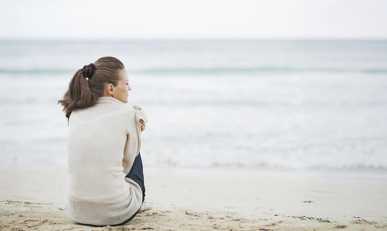 woman sitting on the beach looking to her future