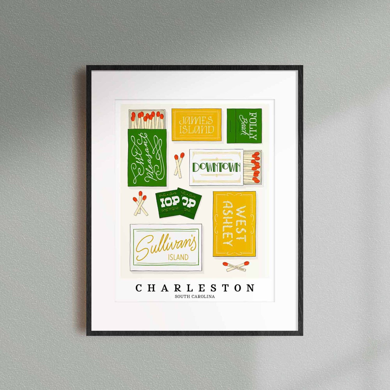 A framed picture of Charleston, South Carolina neighborhoods drawn in various lettering styles on matchboxes. Artwork has a green, yellow and white color scheme.
