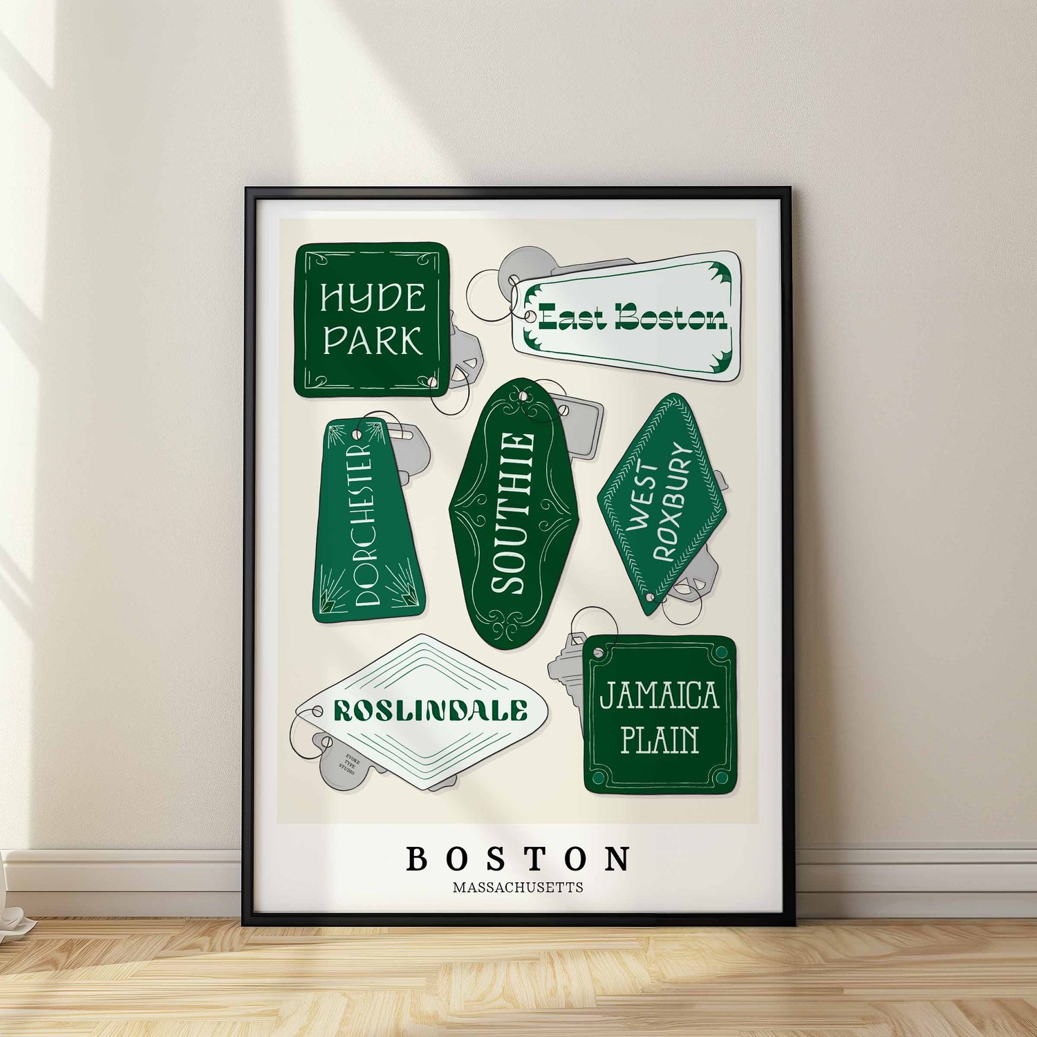 A framed picture of Boston neighborhoods drawn in various lettering styles on key fobs. Artwork has a green and white color scheme