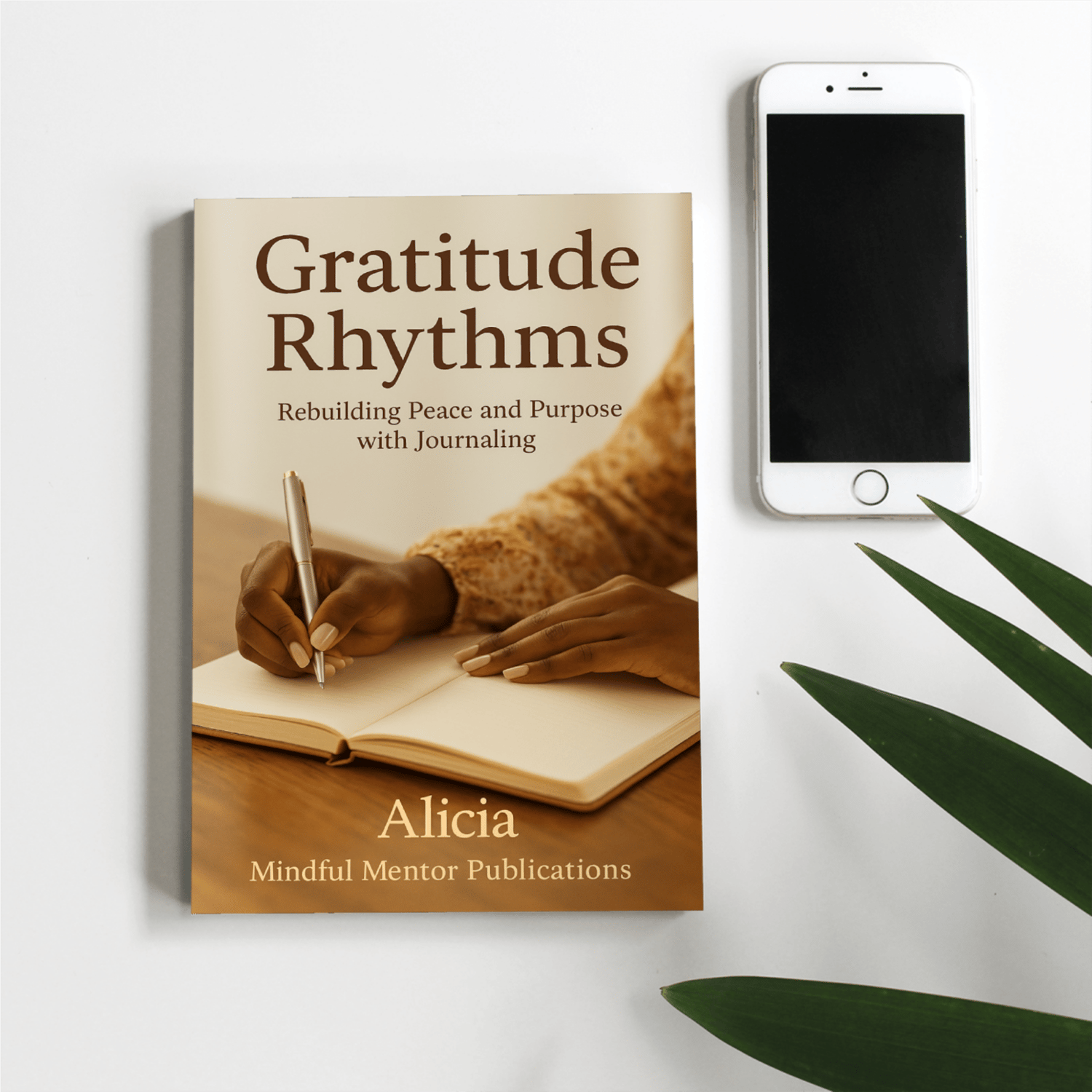 Gratitude Rhythms book next to an iPhone and plant
