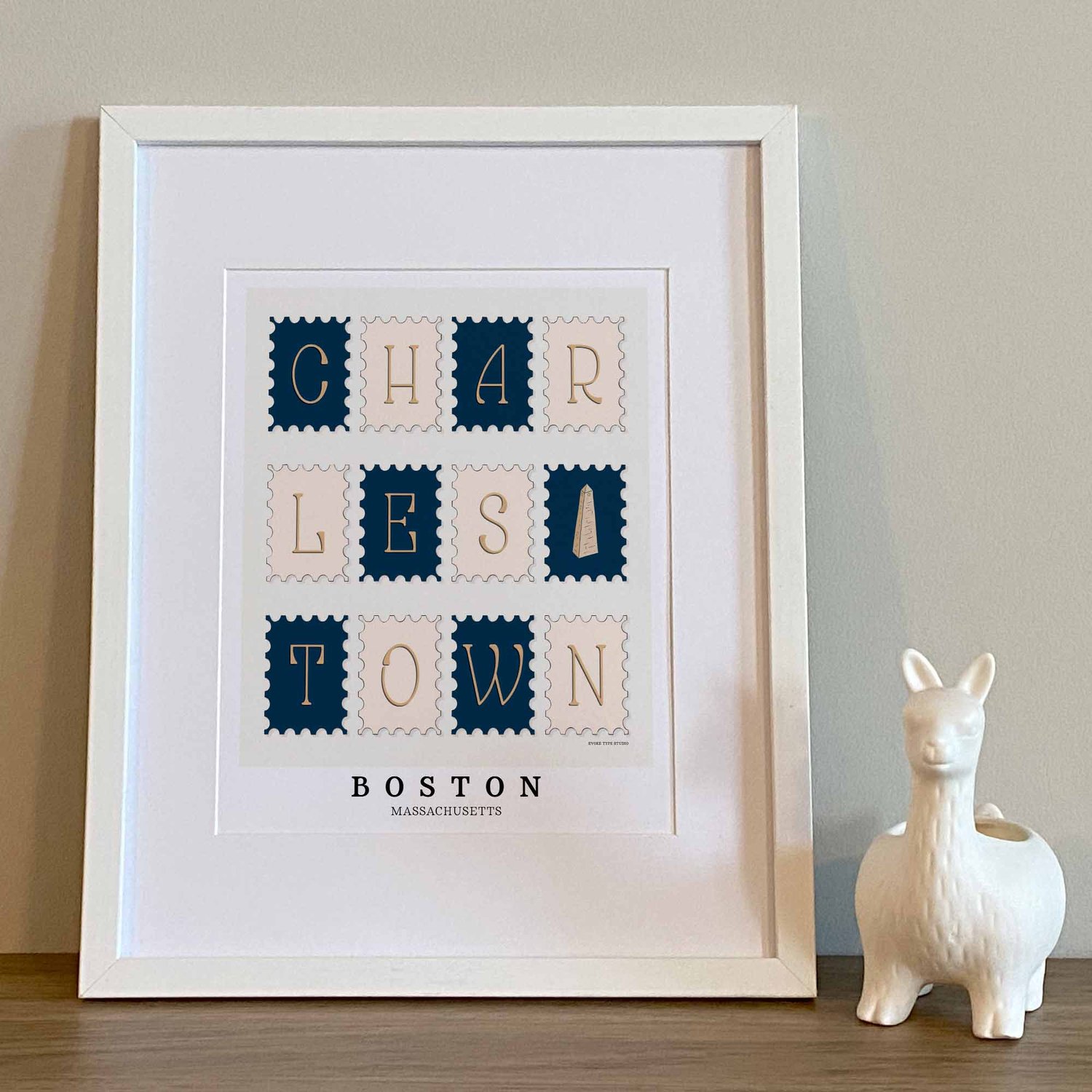 Hand-drawn Charlestown wall art featuring postage stamp–style lettering and an illustration of the Bunker Hill Monument in Nautical colors.