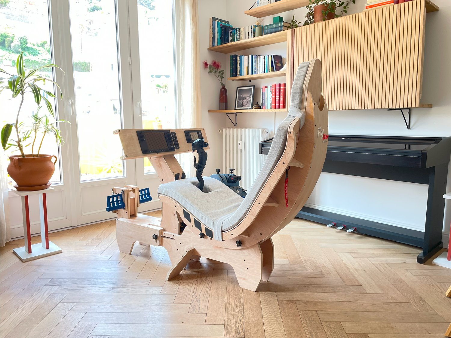 A premium wooden flight simulator cockpit shown fully assembled in a modern living room. Designed to blend with home interiors while supporting high-end flight sim peripherals.