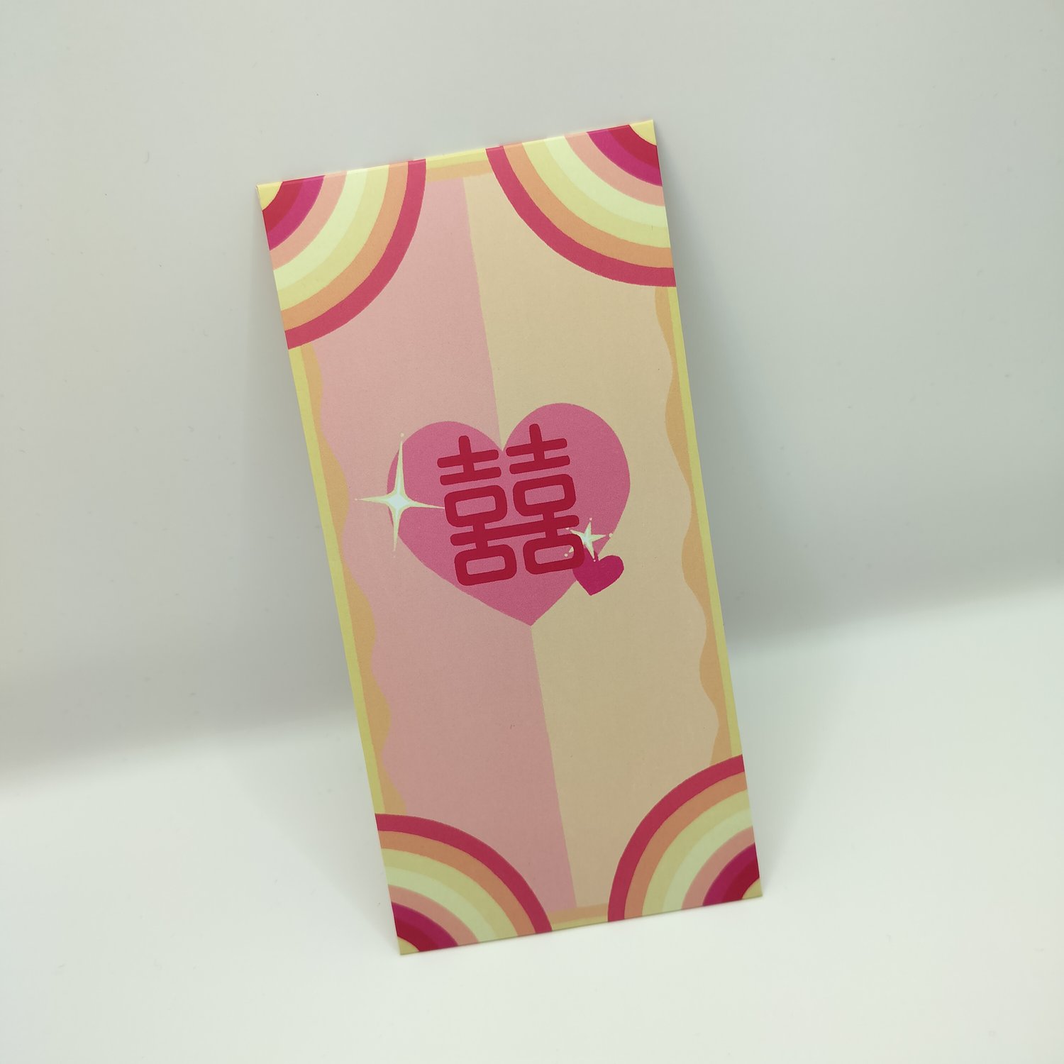 Colorful hongbao with retro rainbow stripe pattern in a lesbian flag-inspired colour scheme, featuring a pink heart with Chinese double happiness characters in the center.