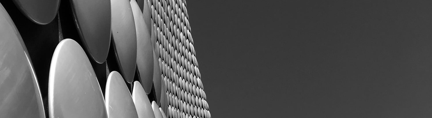 Decorative photographic image in black and white. Image shows an edge of the iconic Selfridge's building in Birmingham, UK, against a clear sky
