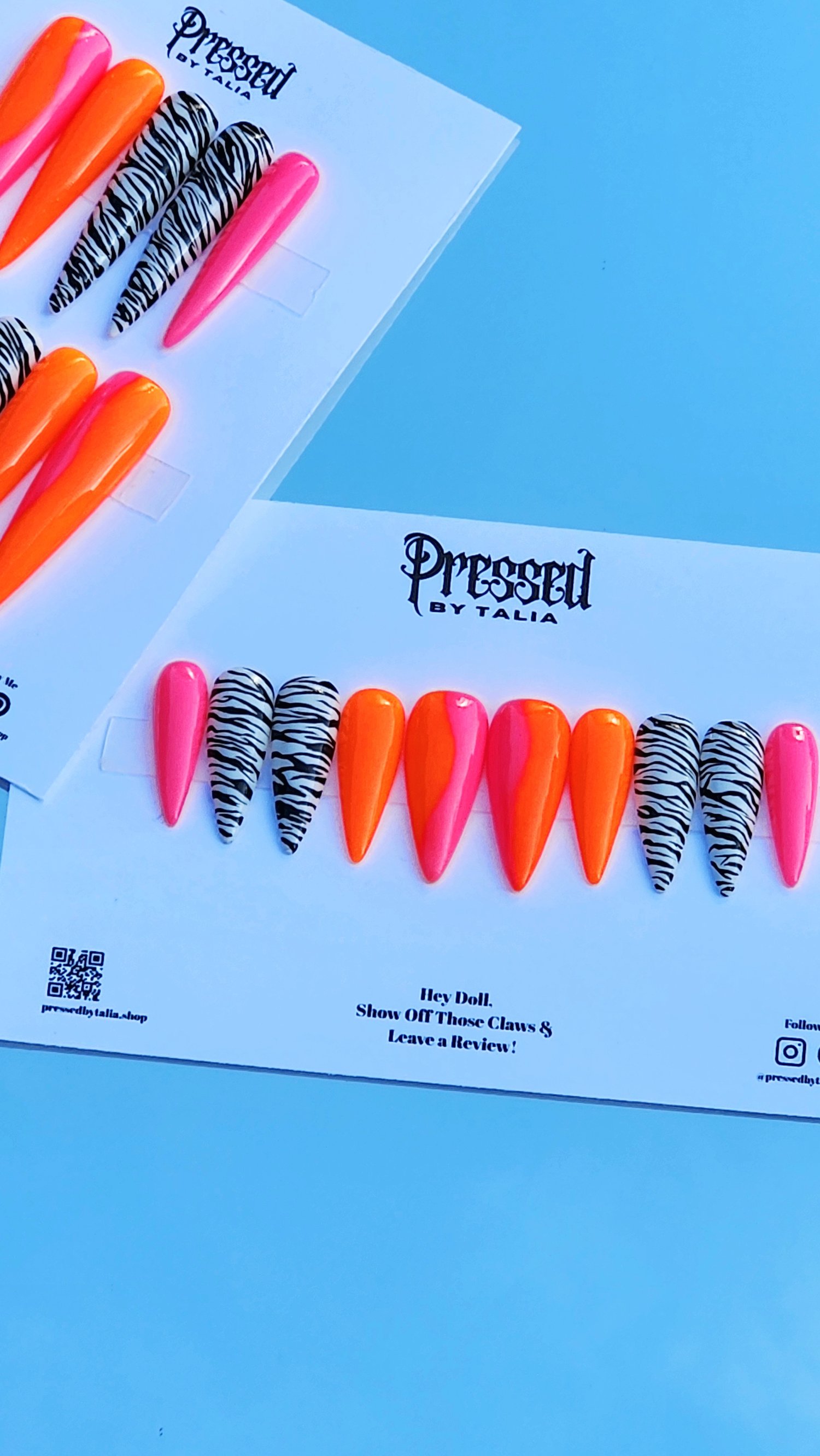 Extra extra long and Medium length stiletto shaped press-on nails with hot pink and neon orange ombre and handmade zebra designs on the nails, close-up picture on Pressed By Talia branded card