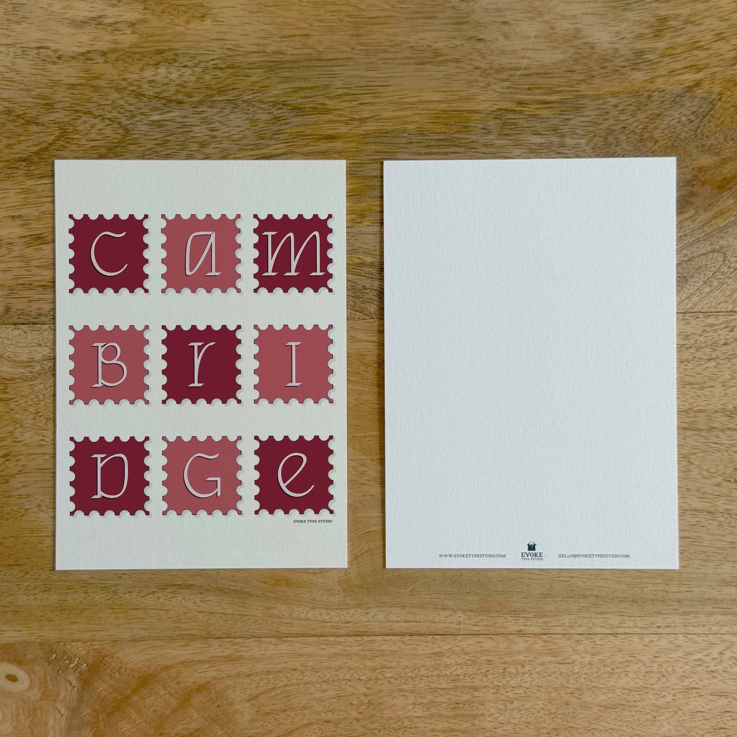 Two sides of a notecard, with postage stamp artwork on the front and a mostly blank back with company contact information at the bottom of the notecard.