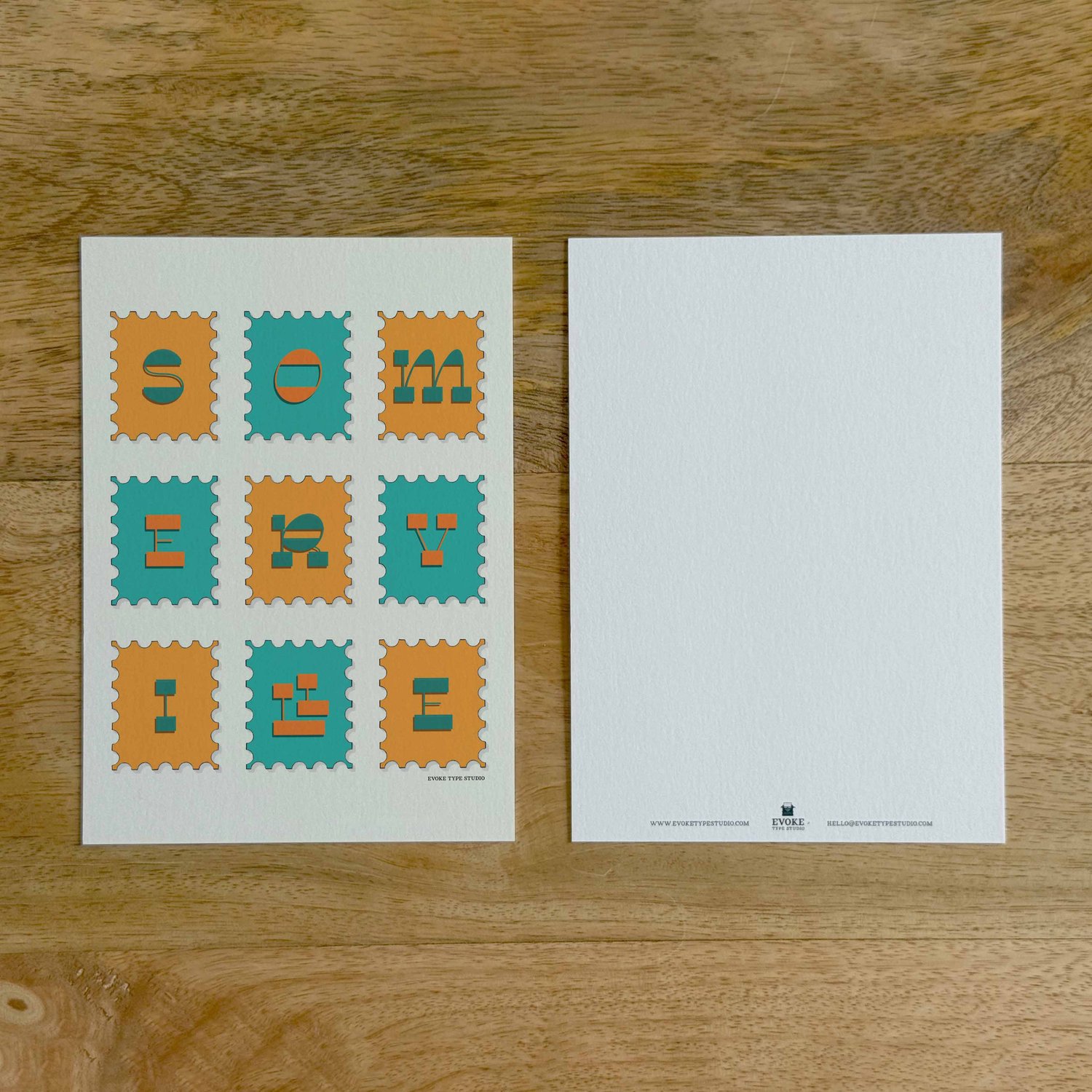 Two sides of a notecard, with postage stamp artwork on the front and a mostly blank back with company contact information at the bottom of the notecard.