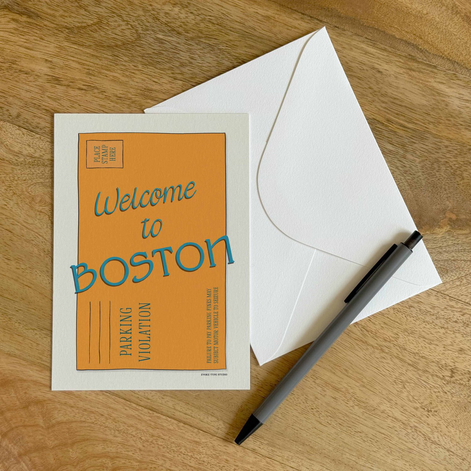 A colorful notecard sitting on a table with a white envelope and pen.