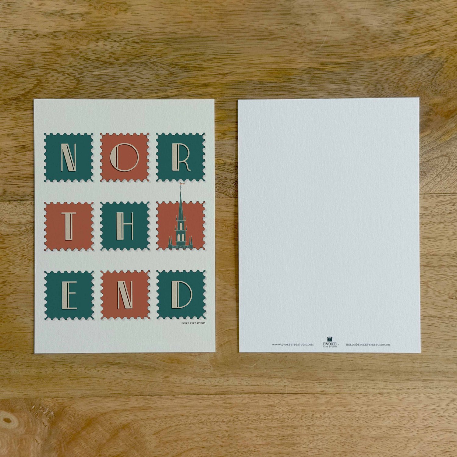 Two sides of a notecard, with postage stamp artwork on the front and a mostly blank back with company contact information at the bottom of the notecard.