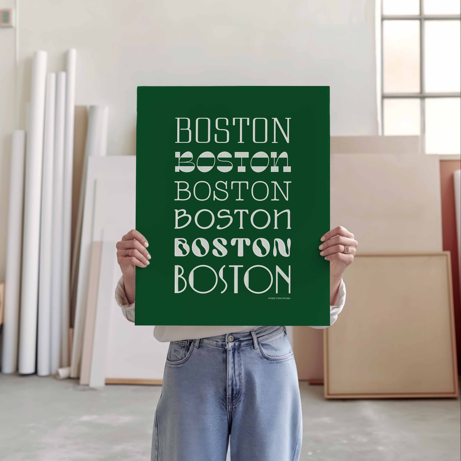 A person holding a poster of a collection of the word "Boston" drawn in various lettering styles
