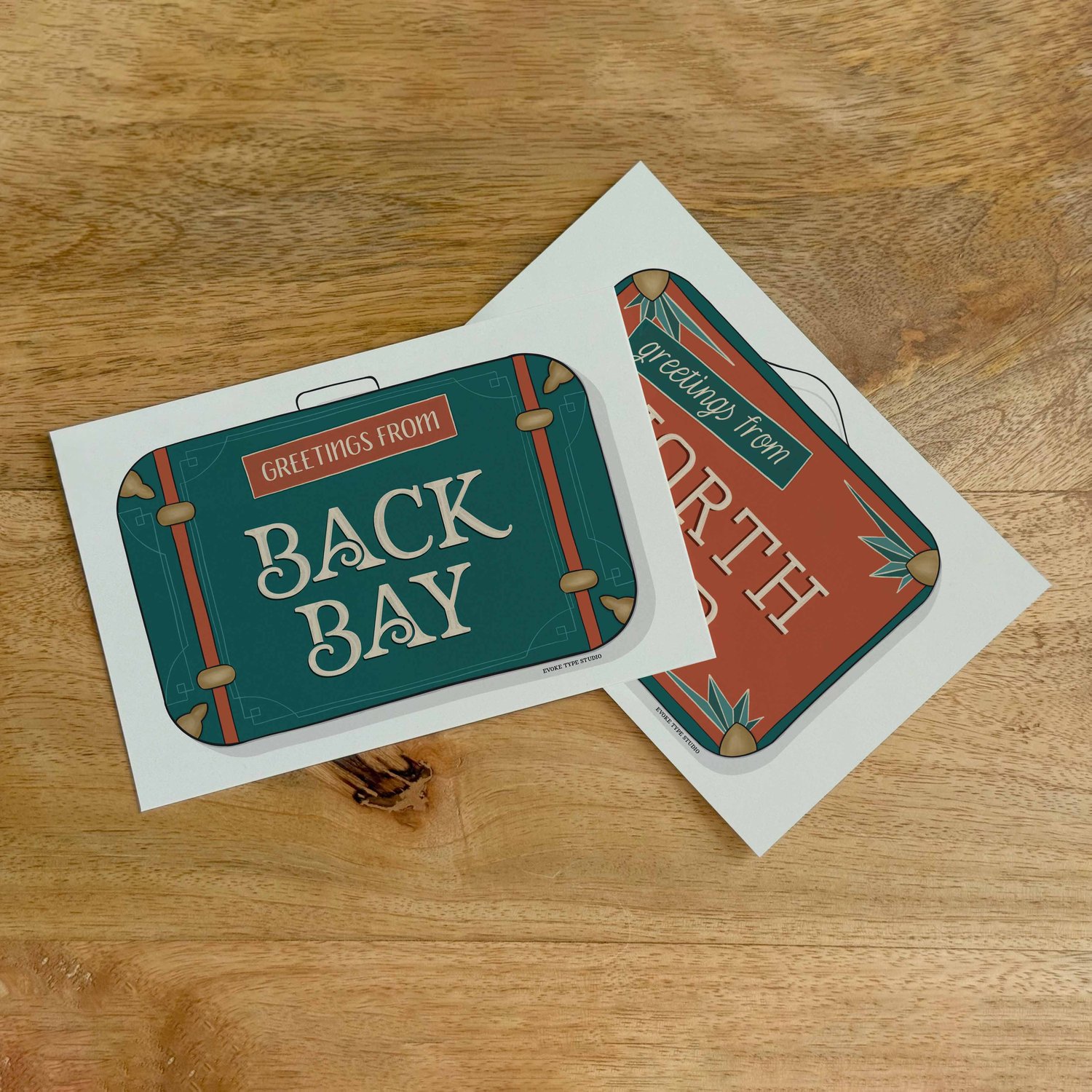 Two postcards, one placed on top of the other. Both postcards feature vintage suitcase illustrations and are for neighborhoods in the Boston, Massachusetts area.