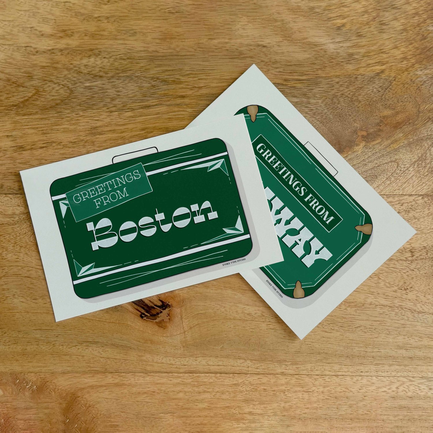Two postcards, one placed on top of the other. Both postcards feature vintage suitcase illustrations and are for the Boston, Massachusetts area.