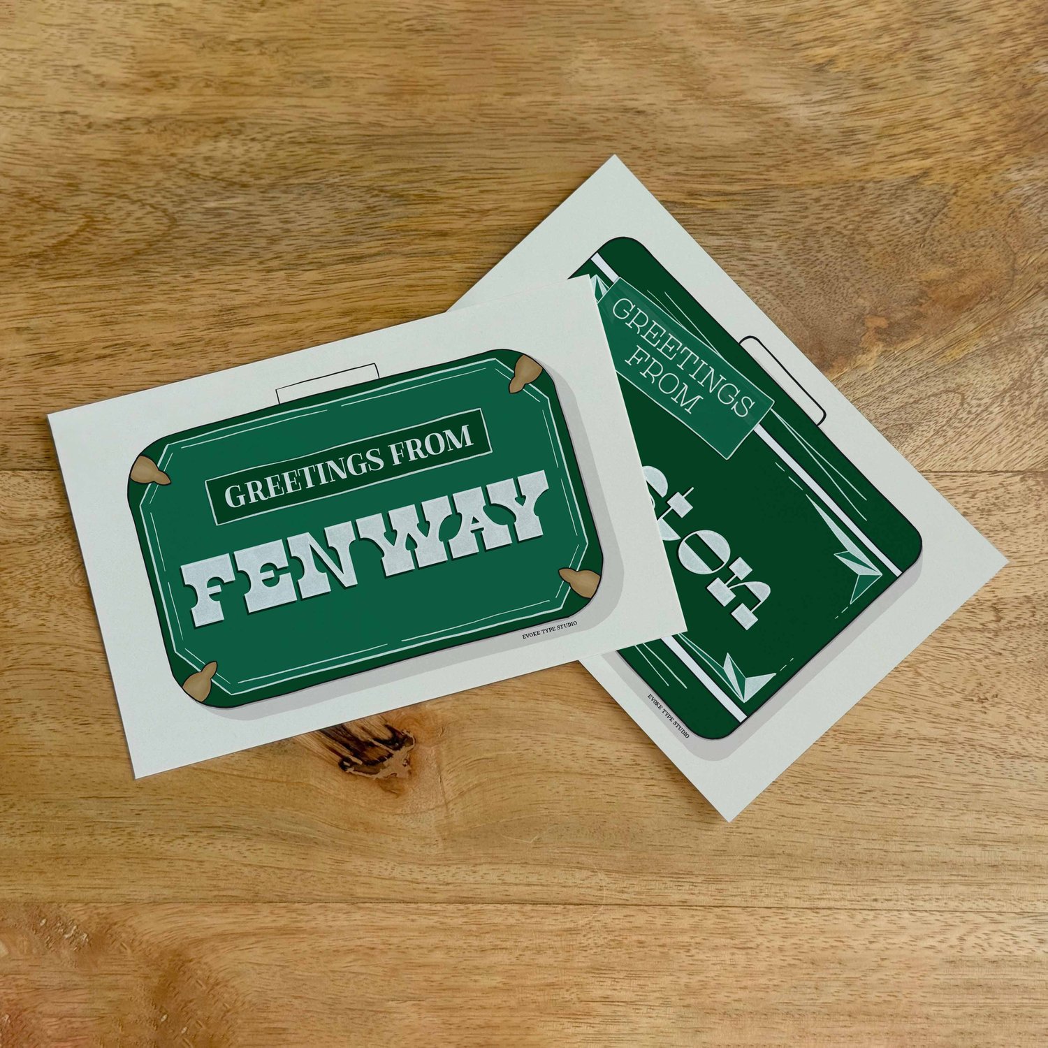 Two postcards, one placed on top of the other. Both postcards feature vintage suitcase illustrations and are for the Boston, Massachusetts area.