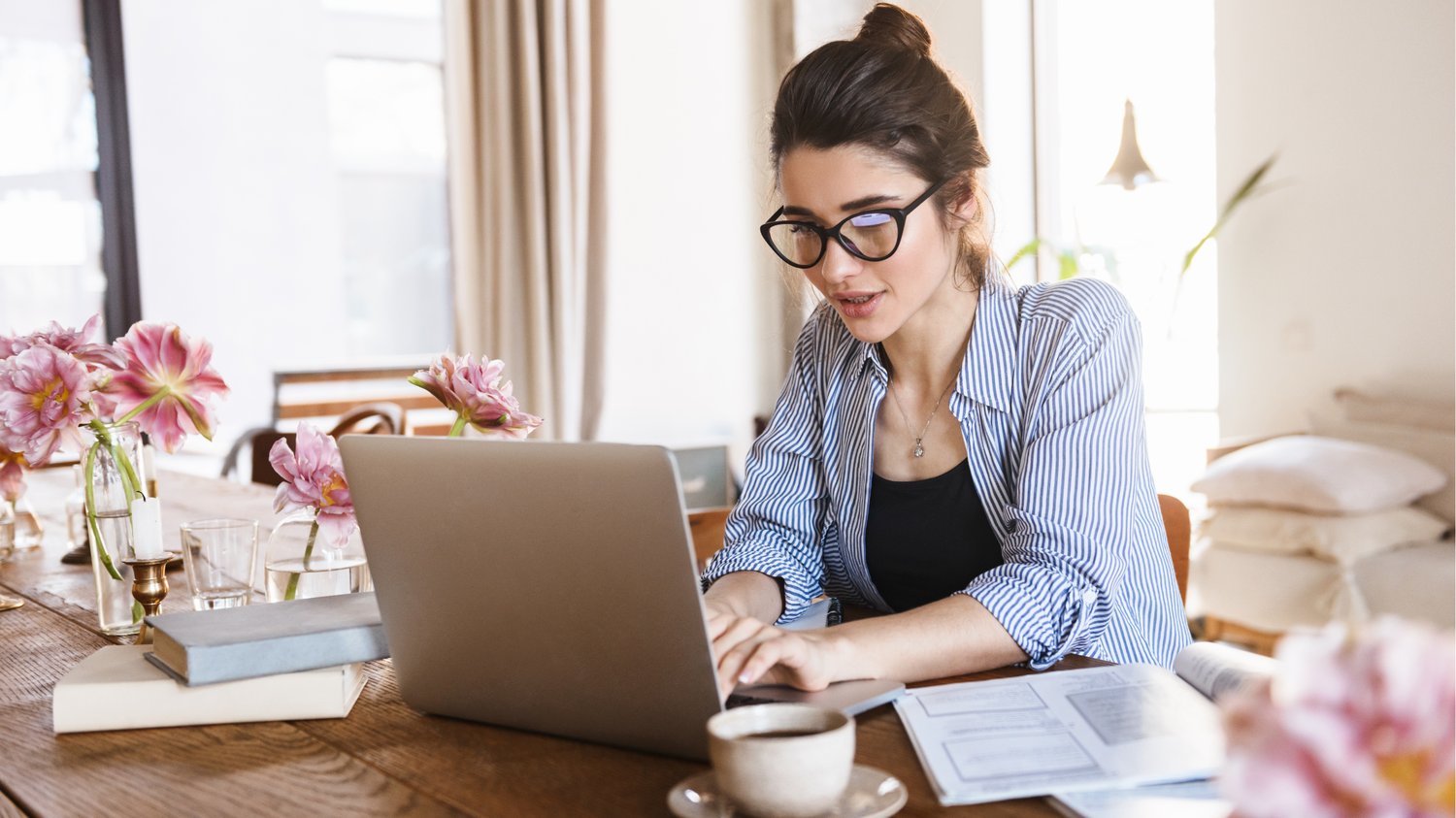 Health coach working on her laptop in a bright home office, creating email content to nurture subscribers and grow her online coaching business.