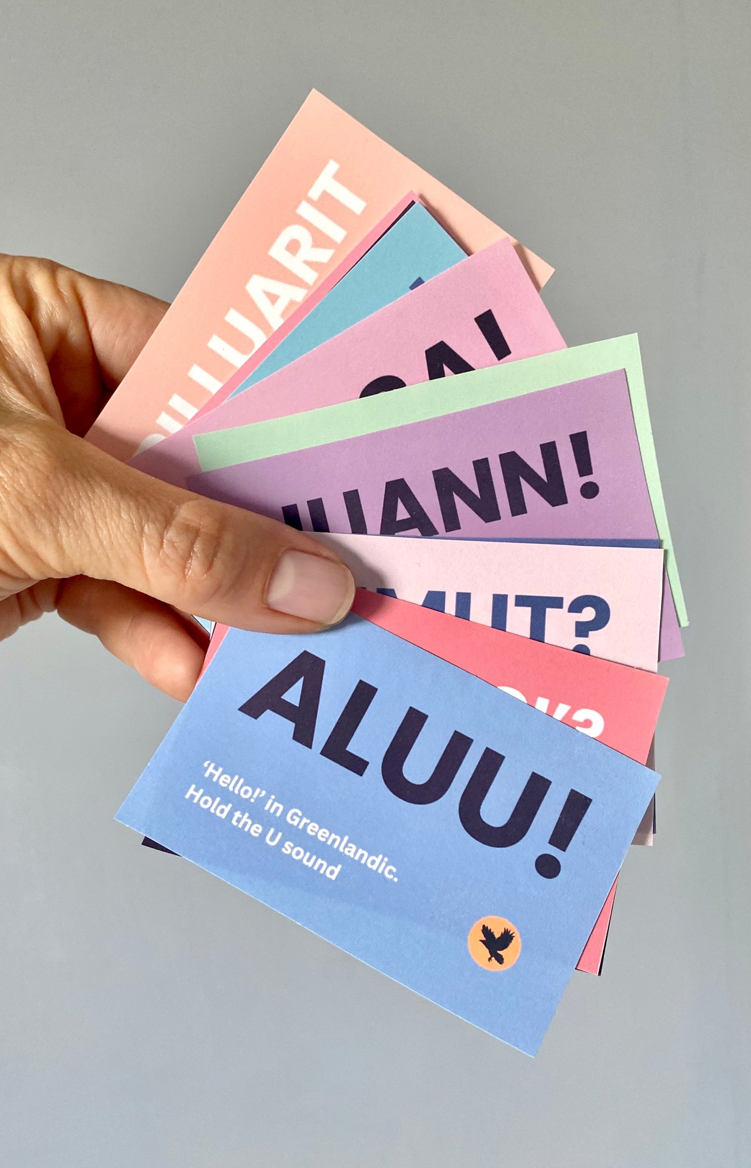 Hand holding the Greenlandic Pocket Deck out in a fan