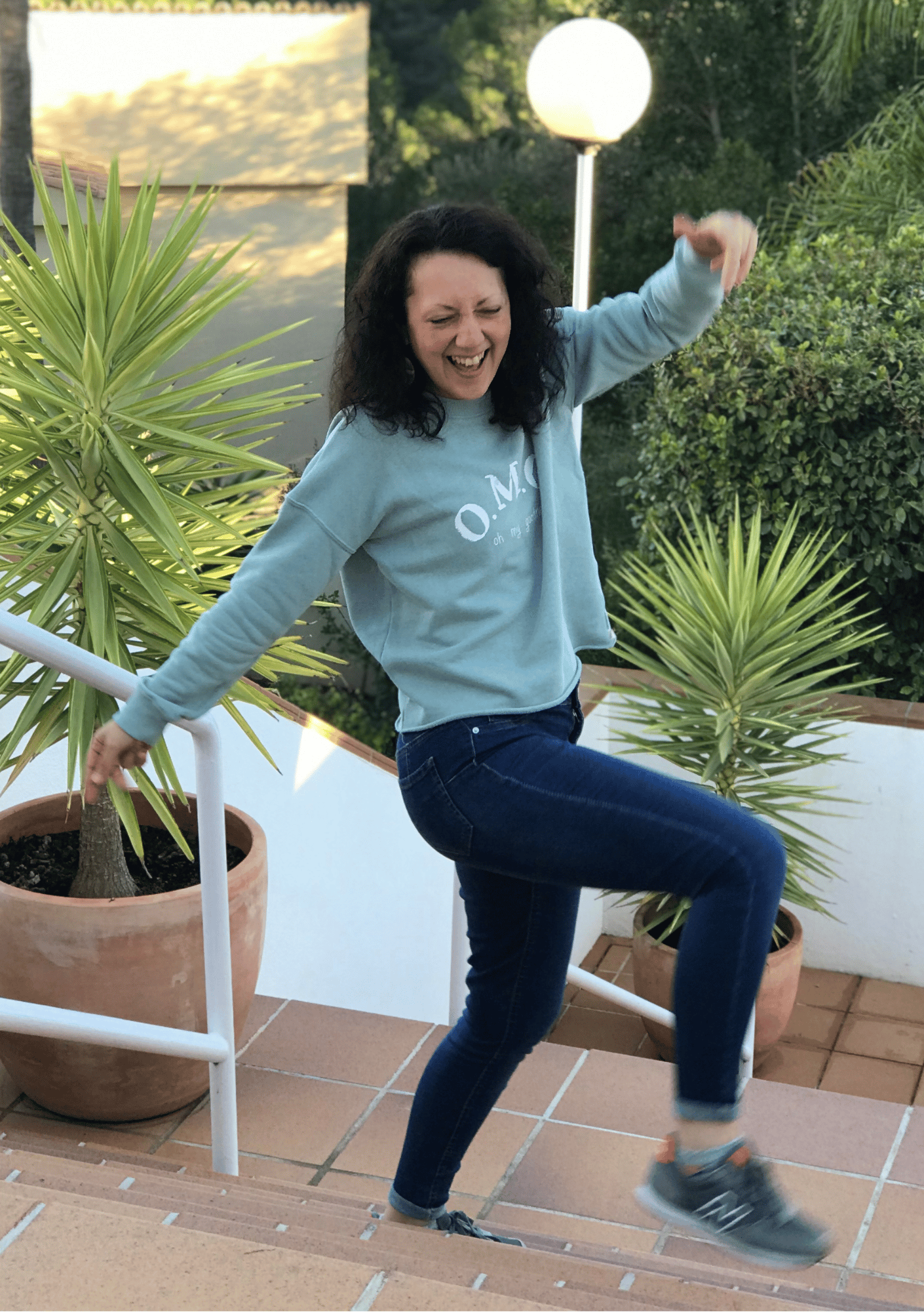 Isabel dancing joyfully on a sunny terrace, radiating freedom, fun, and empowerment - home page of iamisabelbar.com