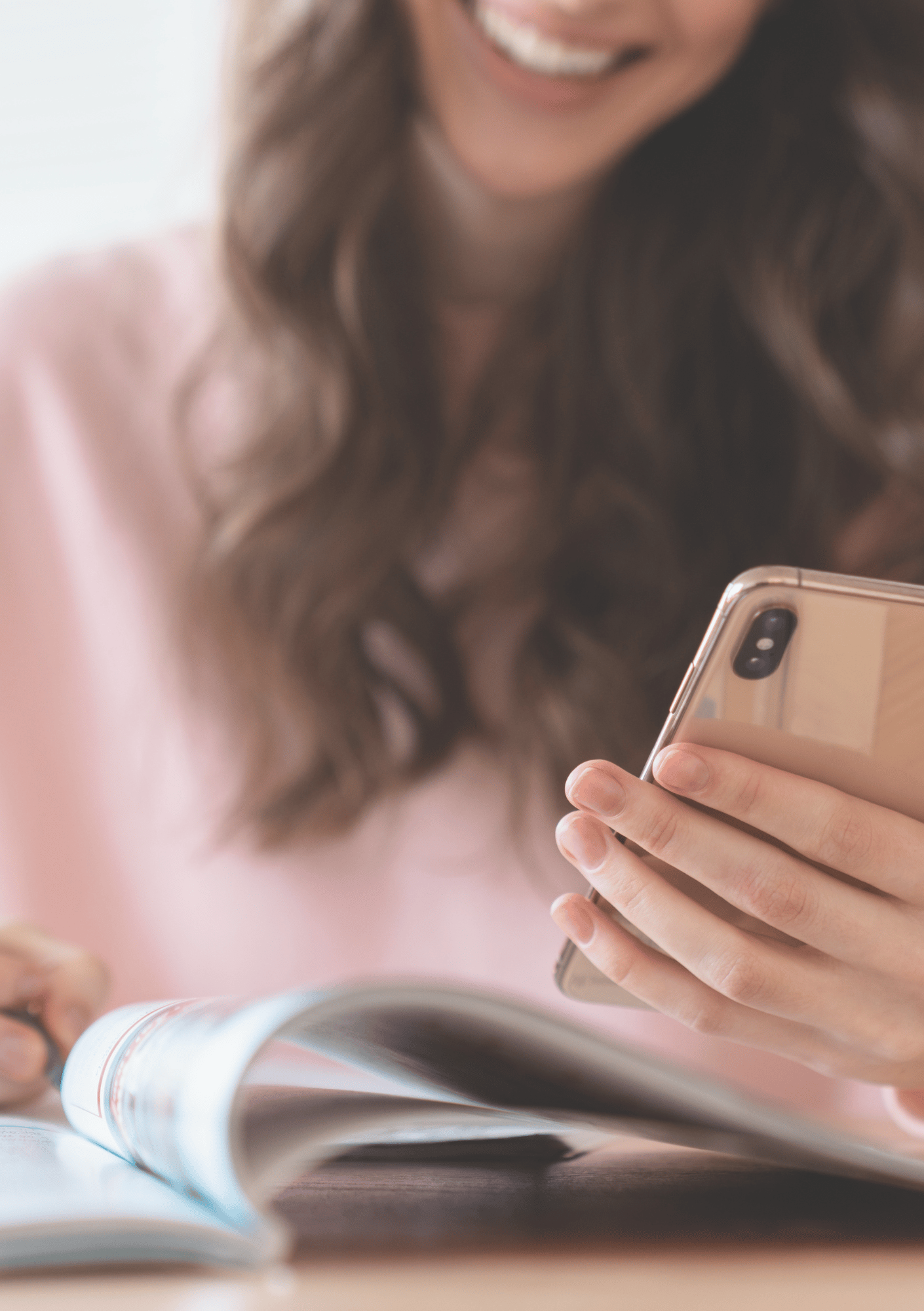Woman smiling while looking at phone and magazine, representing connection, joy, and intuitive support — image for Intuitive Soul Guidance page on iamisabelbar.com