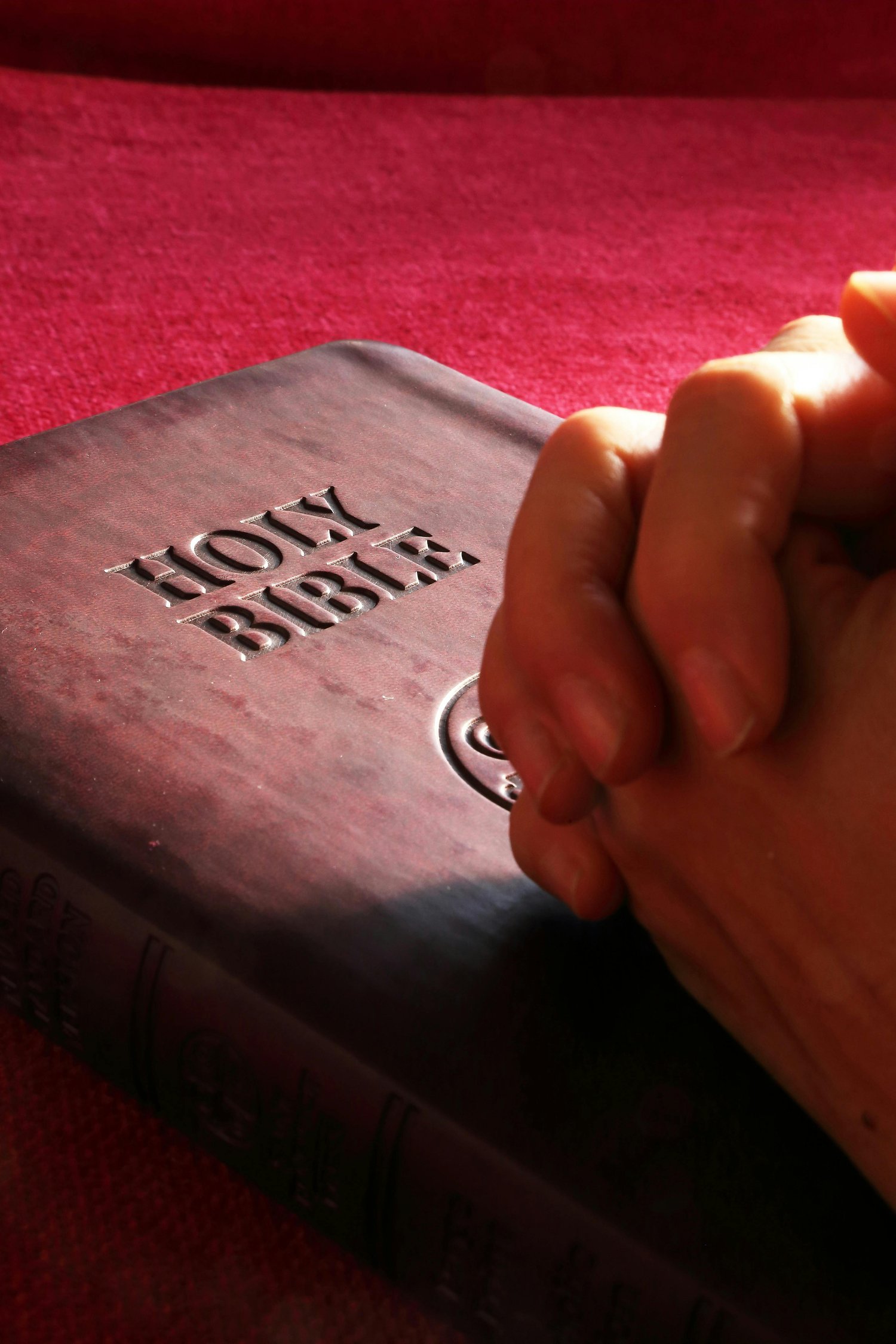 Holy Bible with praying hands