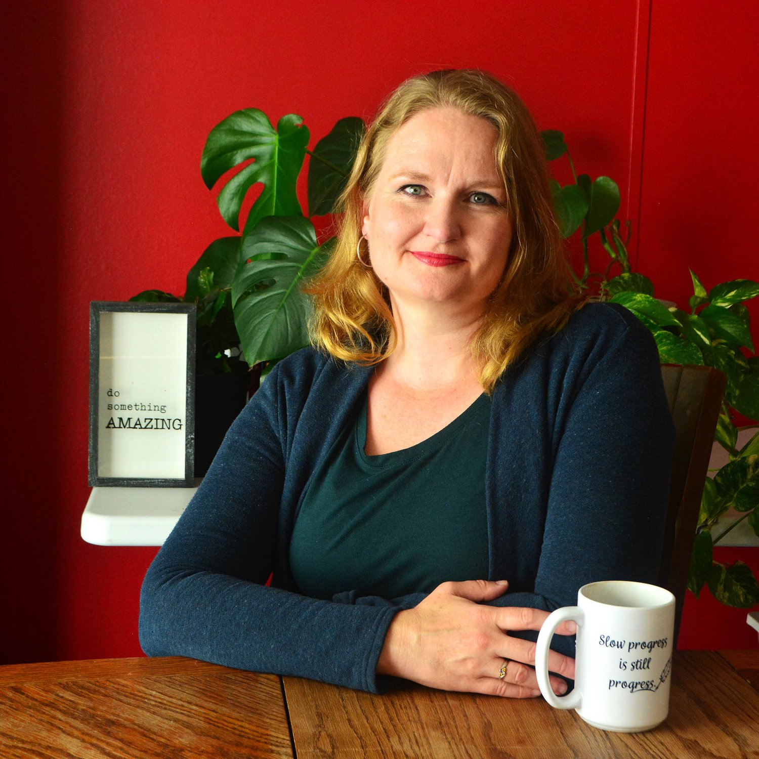 Talena sits at a table with a mug that reads "Slow progress is still progress."