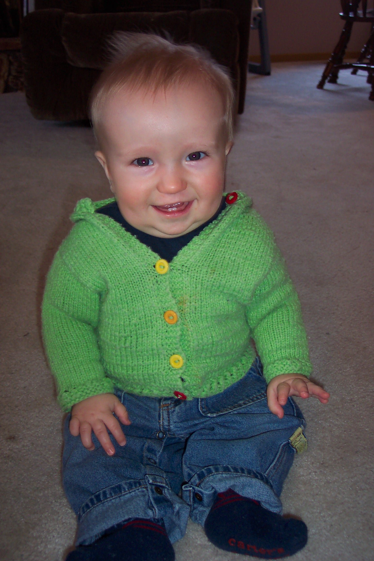 Baby boy in a green knit cardigan.