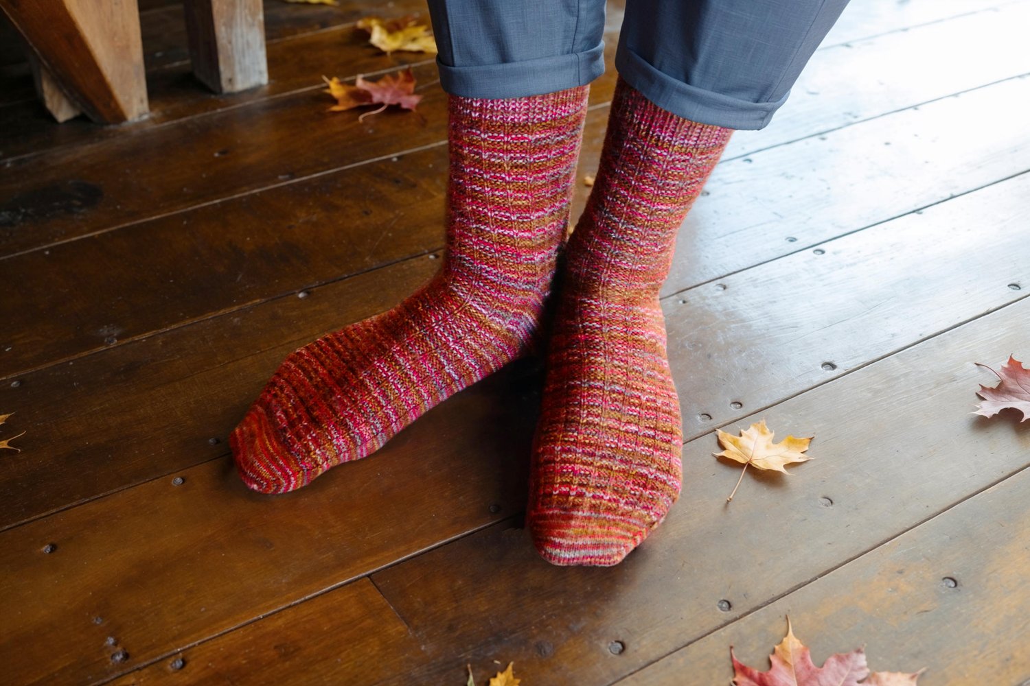 Top view of a pair of male socked feet. Socks have an all-over waffle weave pattern, ribbed cuffs, and raglan toe shaping.