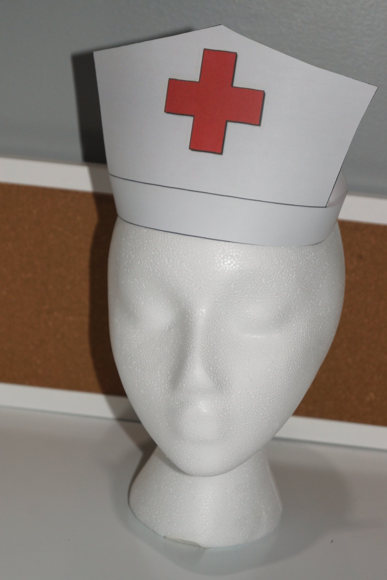 Mannequin wearing printablenurses red cross paper hat for community helper dramatic play.