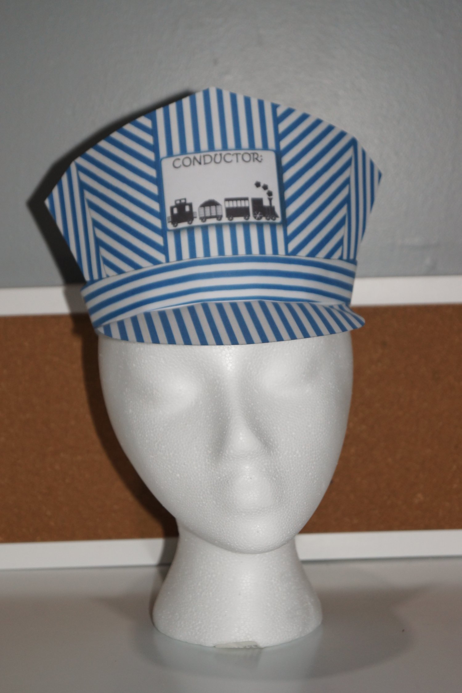 Mannequin wearing printable doctor’s head mirror paper hat for community helper dramatic play.