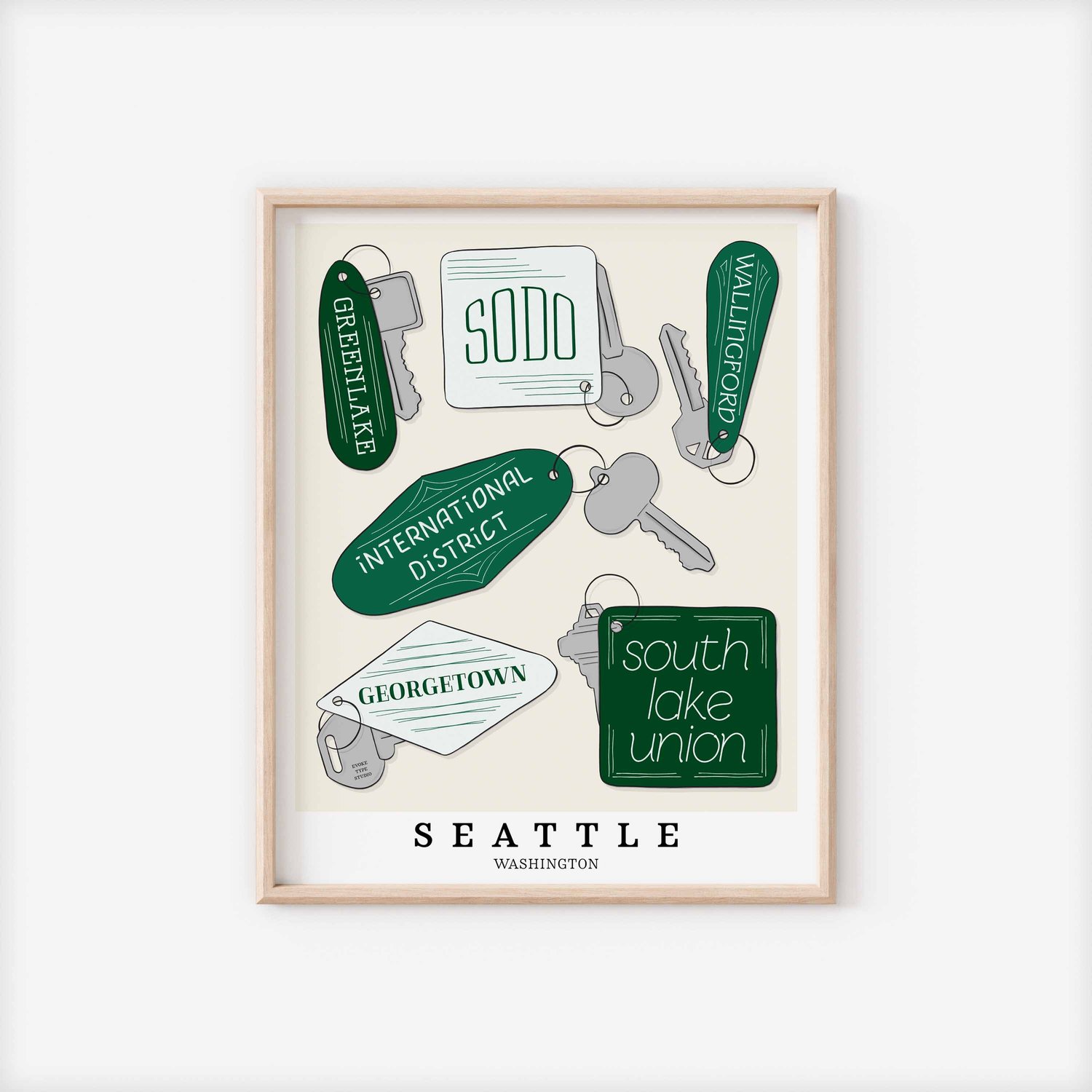 A framed picture of Seattle, Washington neighborhoods drawn in various lettering styles on key fobs. Artwork has a green and white color scheme