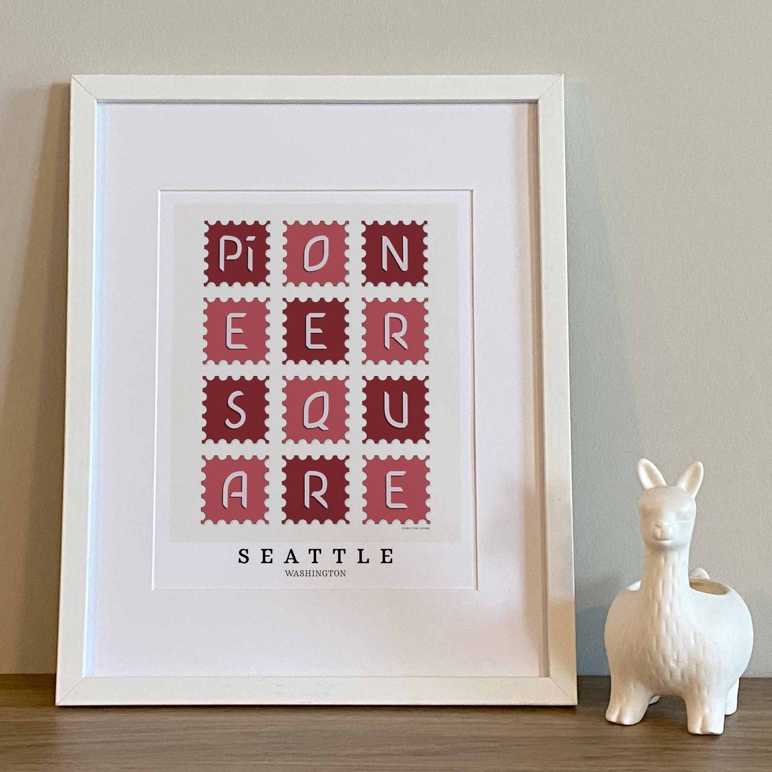 Hand-drawn Pioneer Square wall art in postage stamp style featuring unique lettering in red and white tones