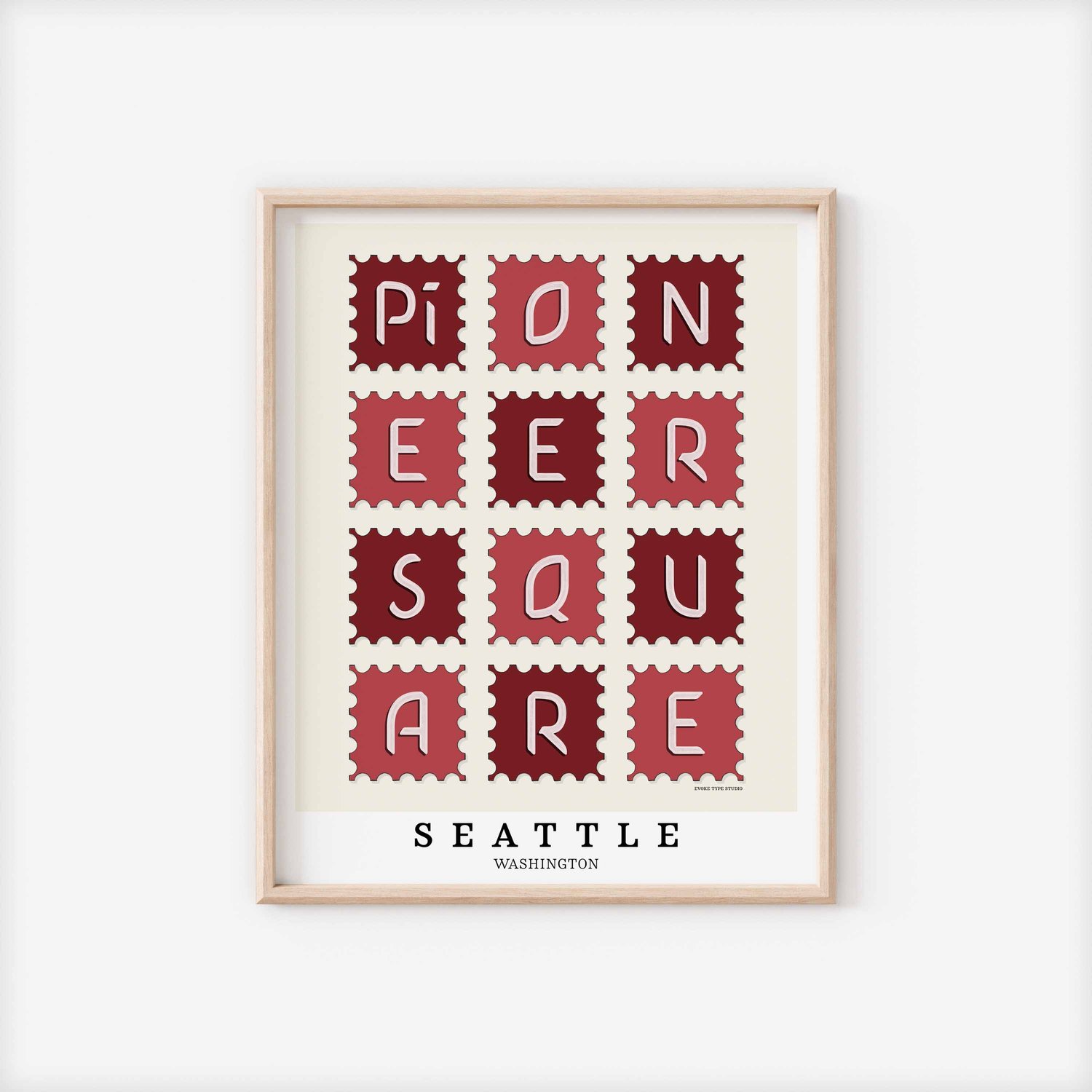 A framed picture of postage stamps featuring the Pioneer Square neighborhood in Seattle, Washington drawn in a unique lettering style. Artwork has a red and white color scheme