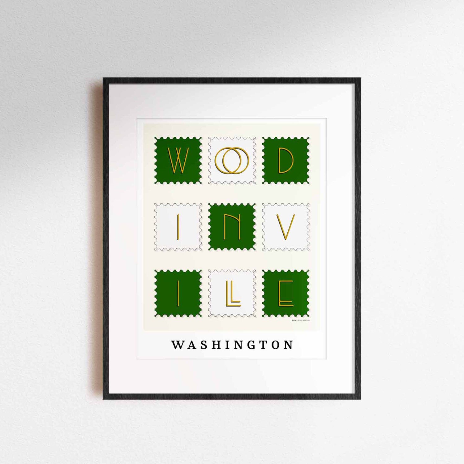 A framed picture of postage stamps featuring Woodinville, Washington drawn in a unique lettering style. Artwork has a green, white and yellow color scheme