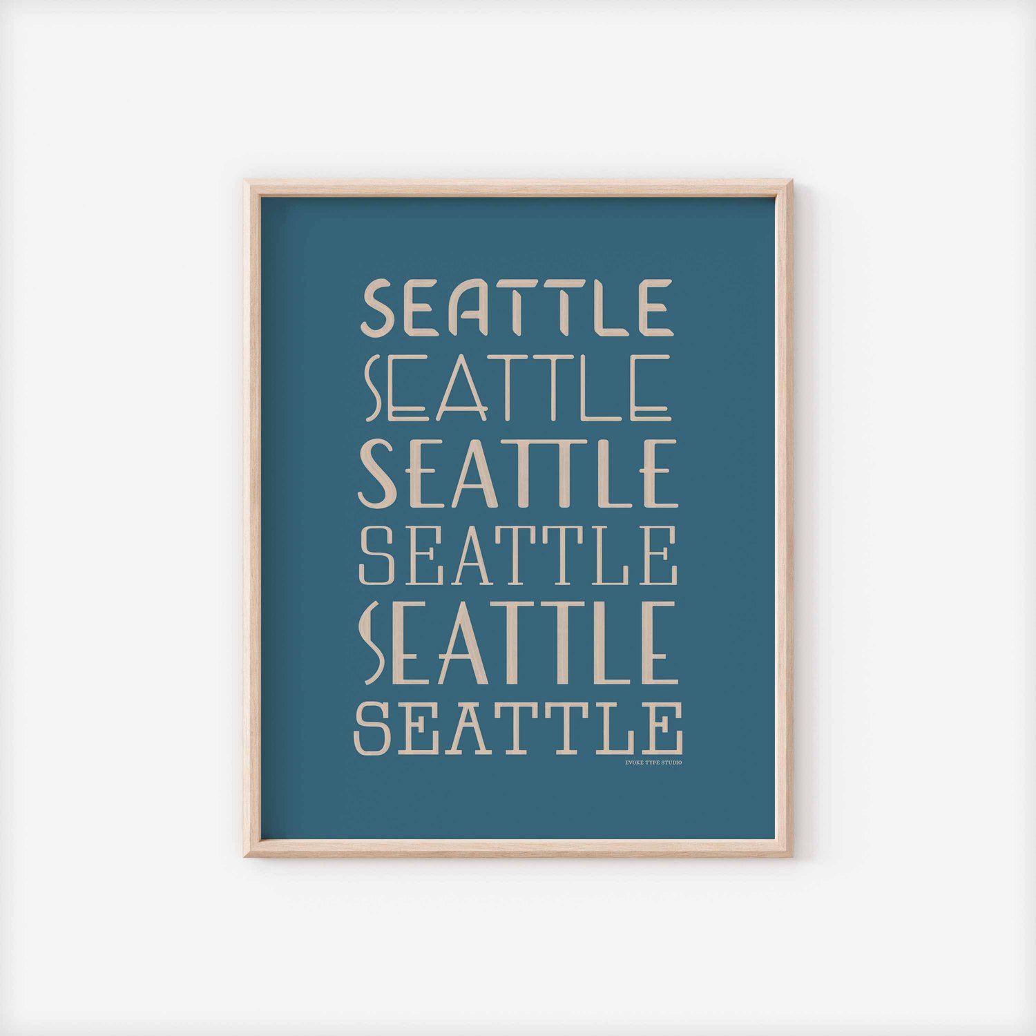 A framed picture of the word "Seattle" drawn in various lettering styles. Artwork has a blue and beige color scheme