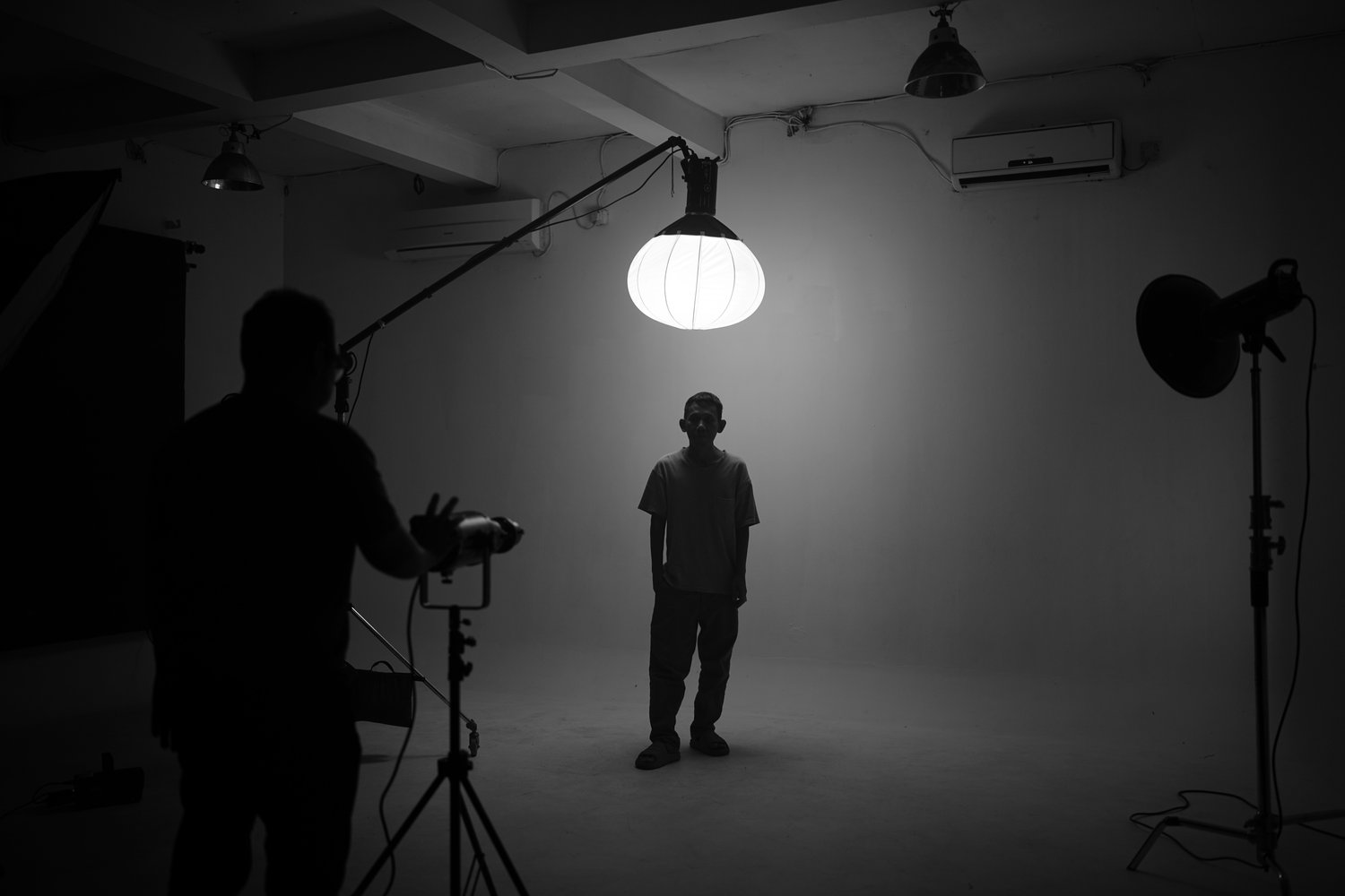 Man standing under photography light in studio