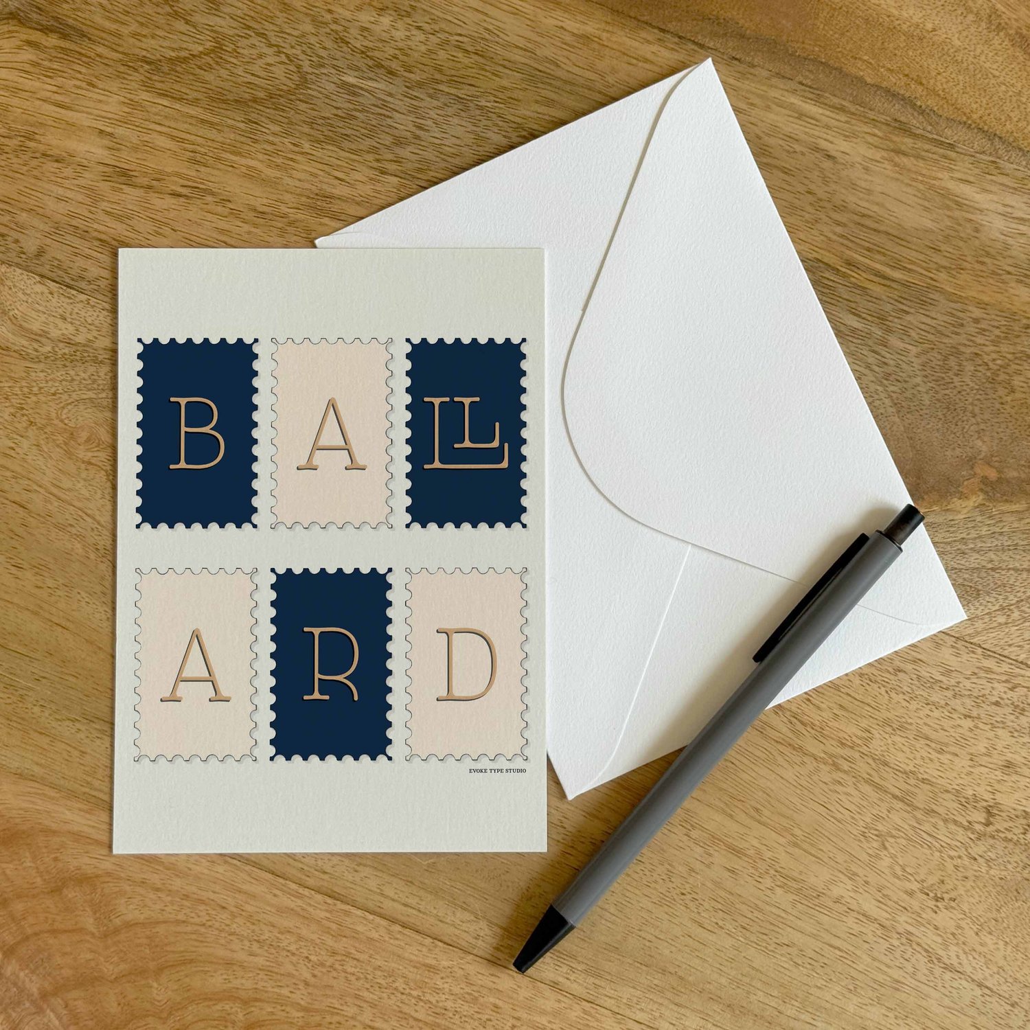 A colorful notecard sitting on a table with a white envelope and pen.