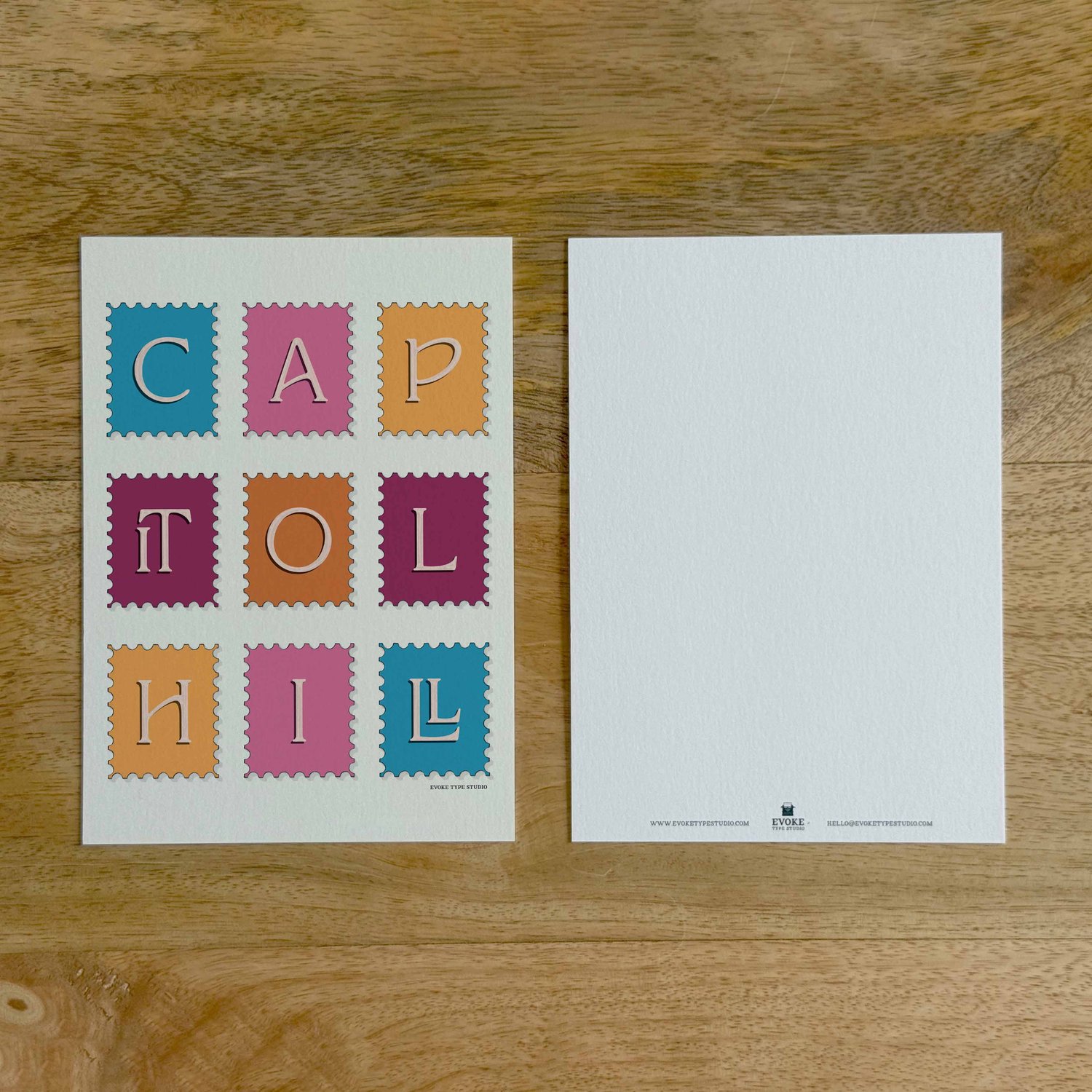 Two sides of a notecard, with postage stamp artwork on the front and a mostly blank back with company contact information at the bottom of the notecard.