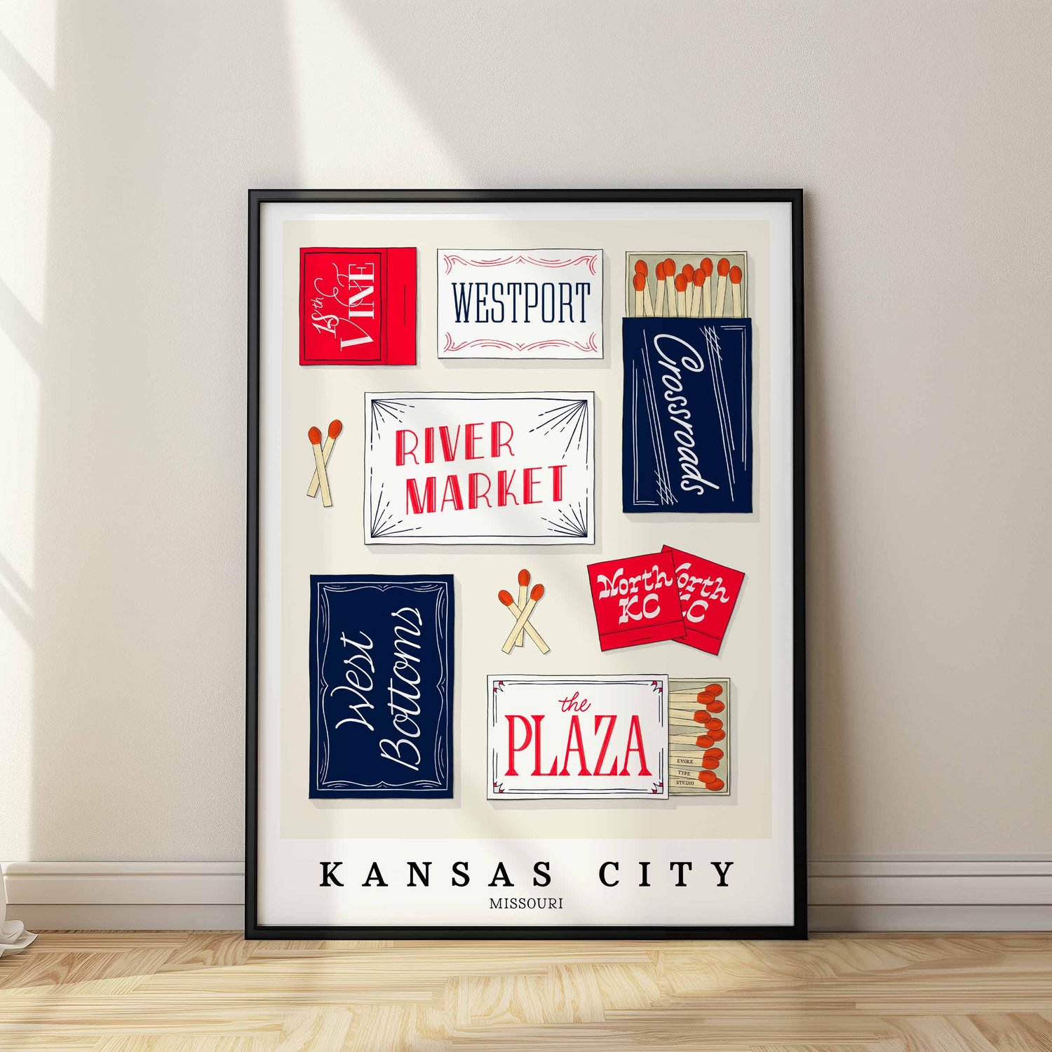 A framed picture of Kansas City, Missouri neighborhoods drawn in various lettering styles on matchboxes. Artwork has a red, white and blue color scheme