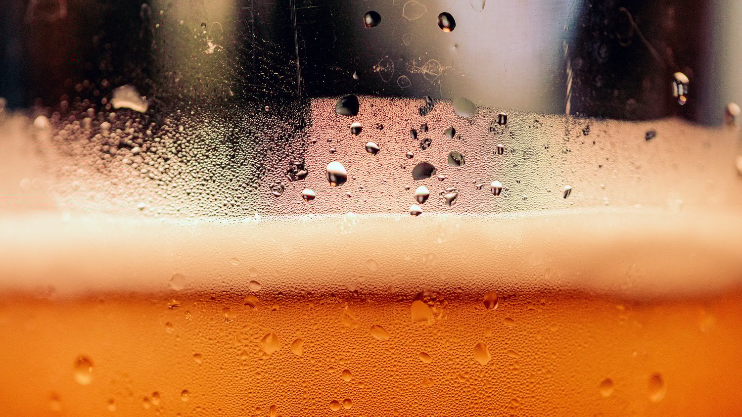 Condensation on a glass of beer with froth and amber liquid, illustrating creativity as a process that needs time to ferment, The Creative Guide.
