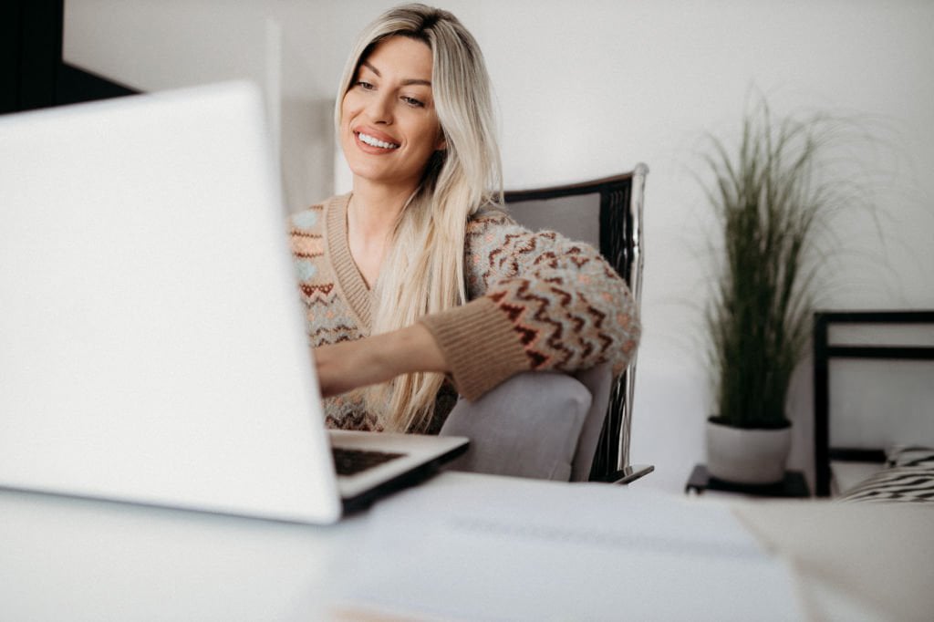 woman smiling being coached online through a free exploration session