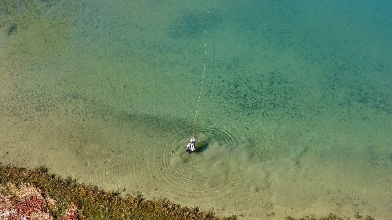 Overhead drone shot of fly angler Matt Campbell casting in a crystal-clear lake in Northeast Ohio.