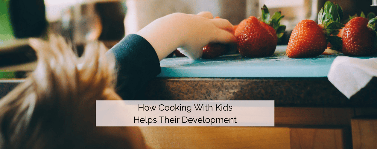 How cooking with kids helps their development - child reaching for strawberries