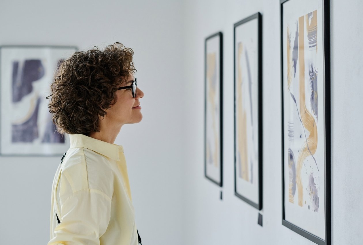 An art collector inspecting artwork at a gallery.