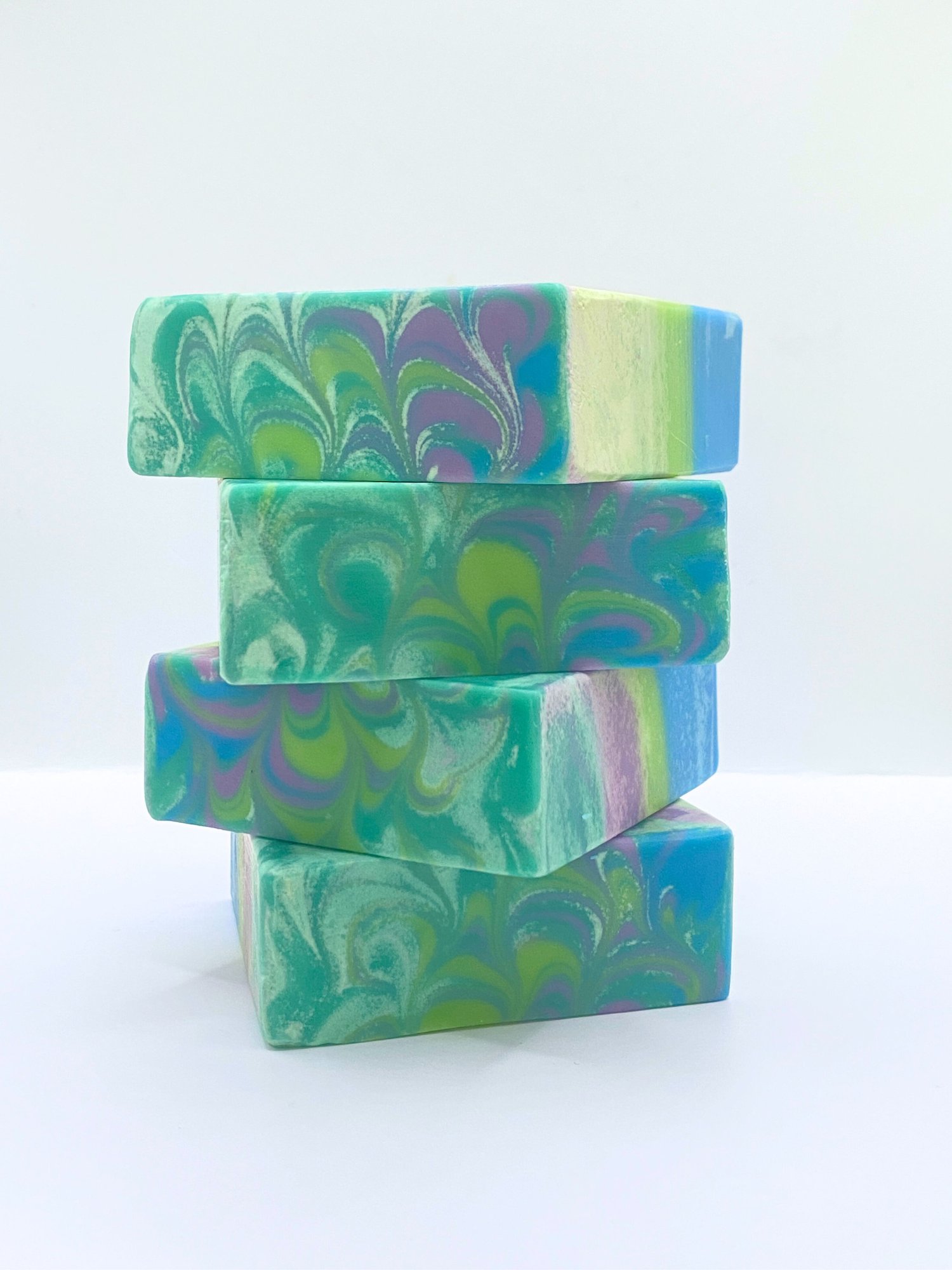 Handmade soap scented with rosemary essential oil and swirled with green, purple, teal, and blue